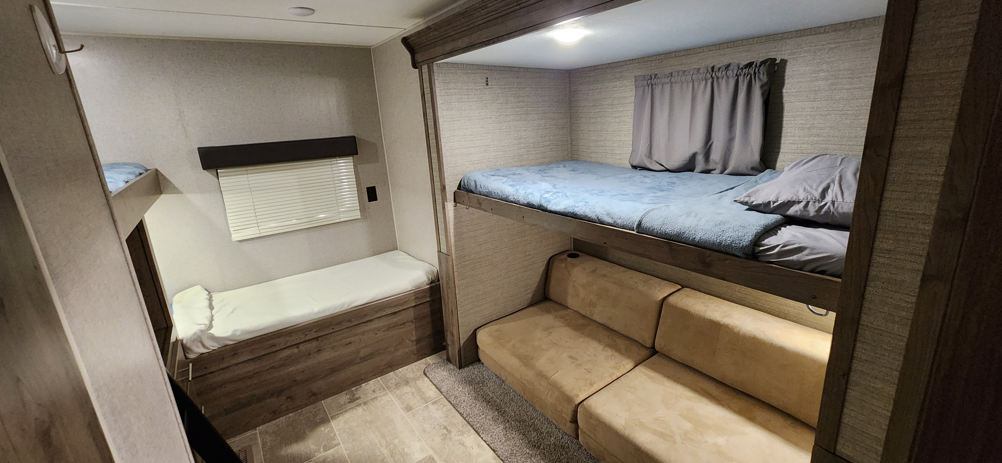Spacious rv rental interior featuring bunk beds, a sofa, and a padded bench for sleeping.. Aspen Trail Aspen Trail Trailer 2019