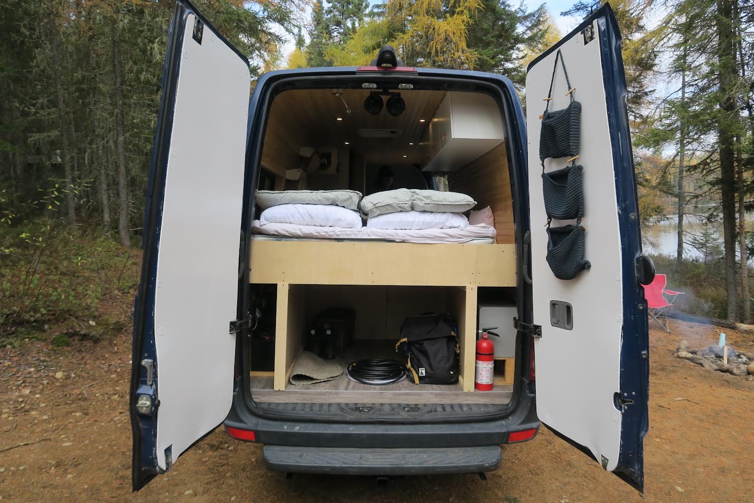 Get ready for van life! This **rv rental** opens to a cozy bed, organized storage, and a scenic lake campsite.. Field Van Sprinter Mercedes 2014