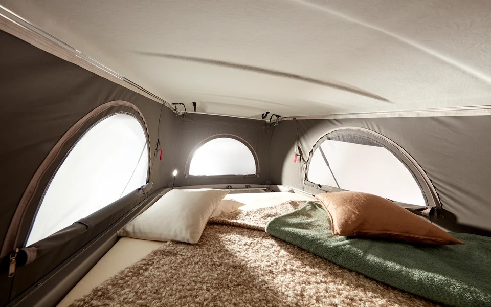 Cozy RV rental pop-top tent bed with arched windows and ample light for a comfortable sleeping area.. Bürstner CAMPEO C600 2024