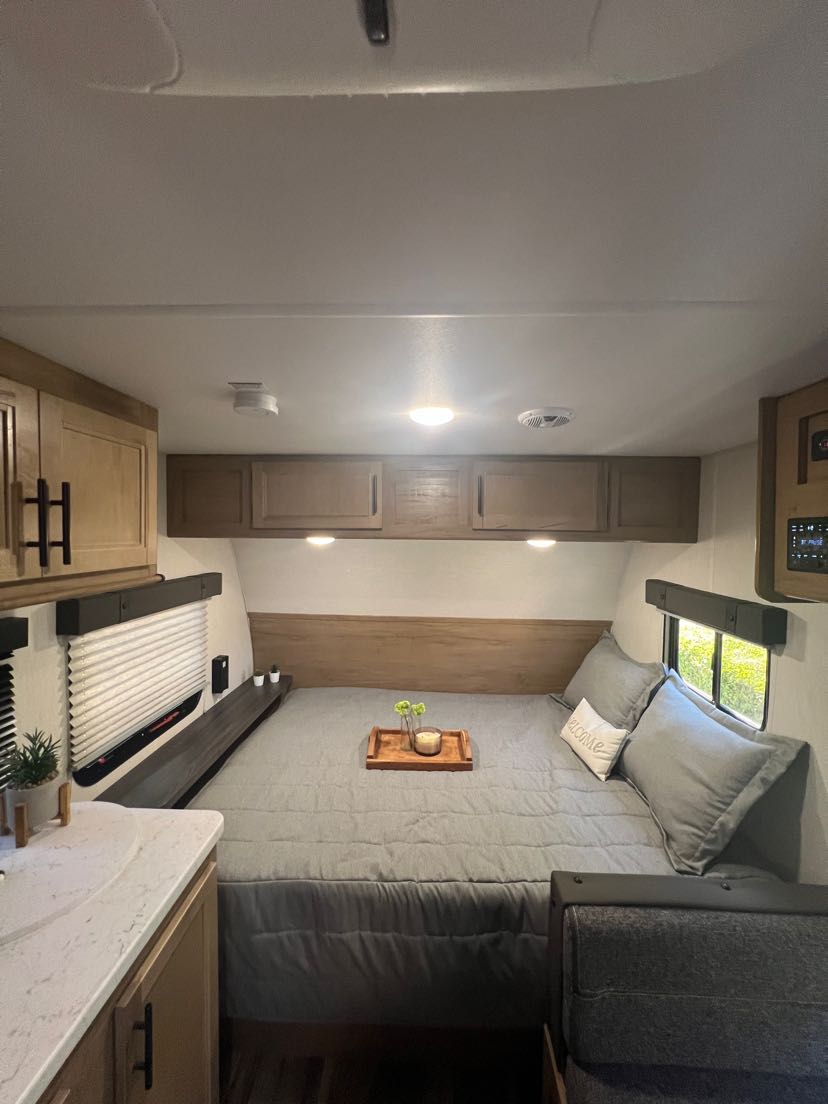 Cozy RV rental interior showing a comfortable bedroom with a large bed, kitchen counter, and living area. Perfect for travel!. Forest River Cherokee Wolf Pack Toy Hauler 2024