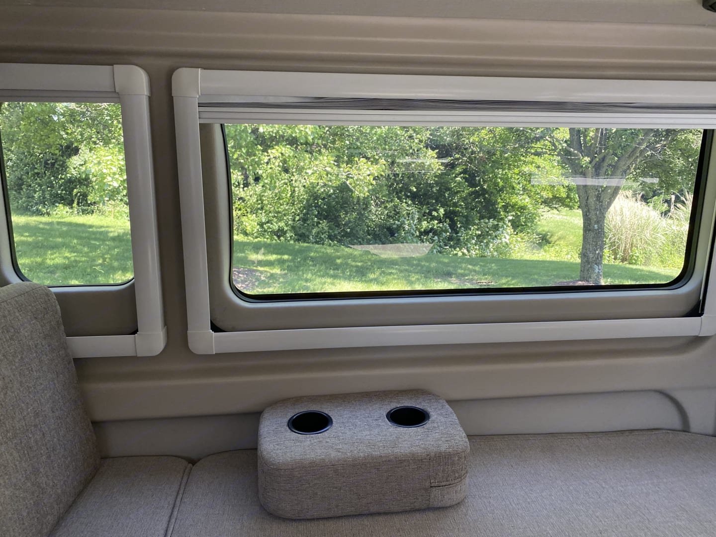 This RV rental features a comfortable lounge area with cup holders and serene nature views from its large windows.. Thor Tellaro 2021