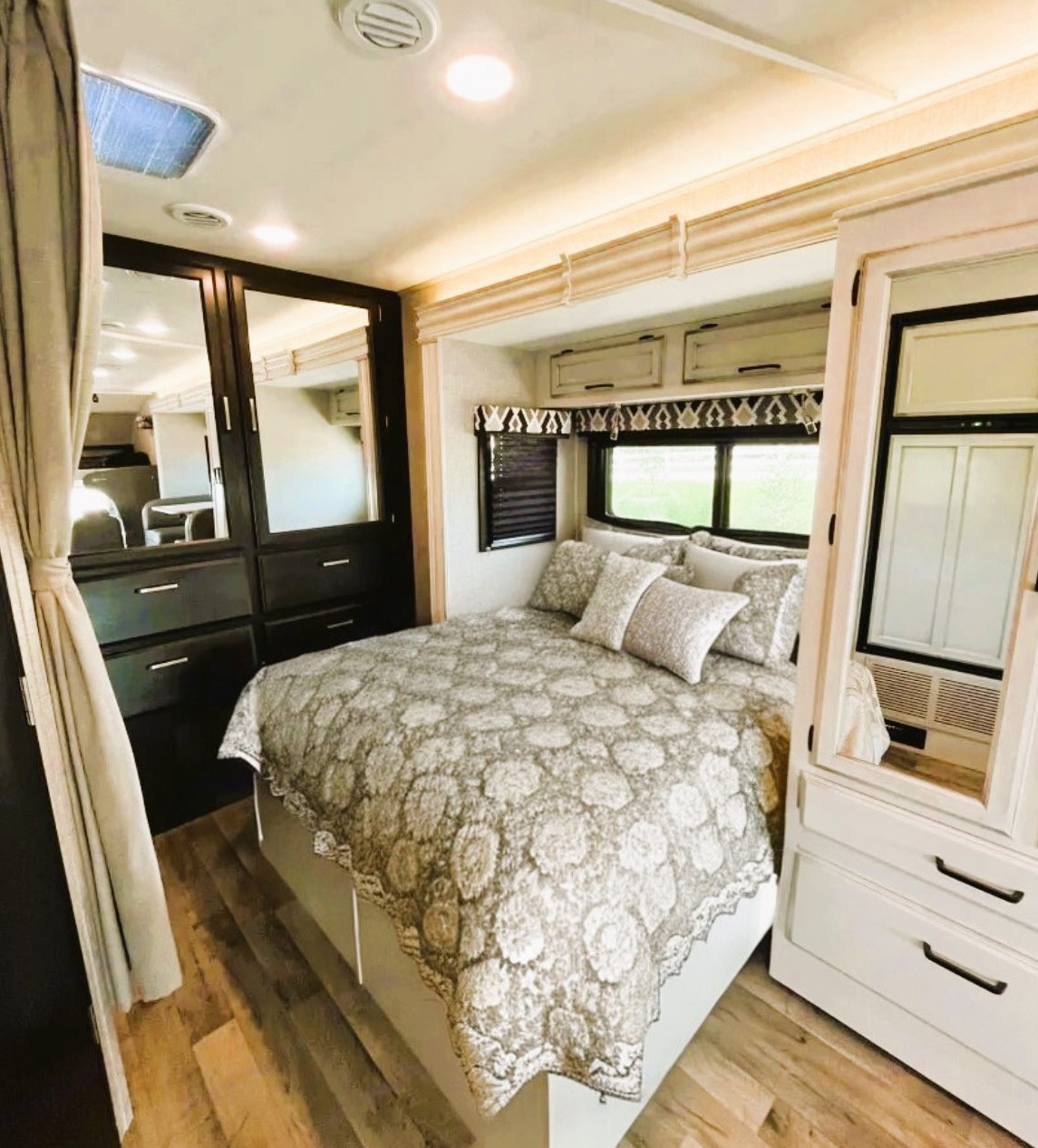 Experience a comfortable RV rental bedroom featuring patterned bedding, built-in storage, and bright windows, ideal for travel.. Jayco Redhawk 2022