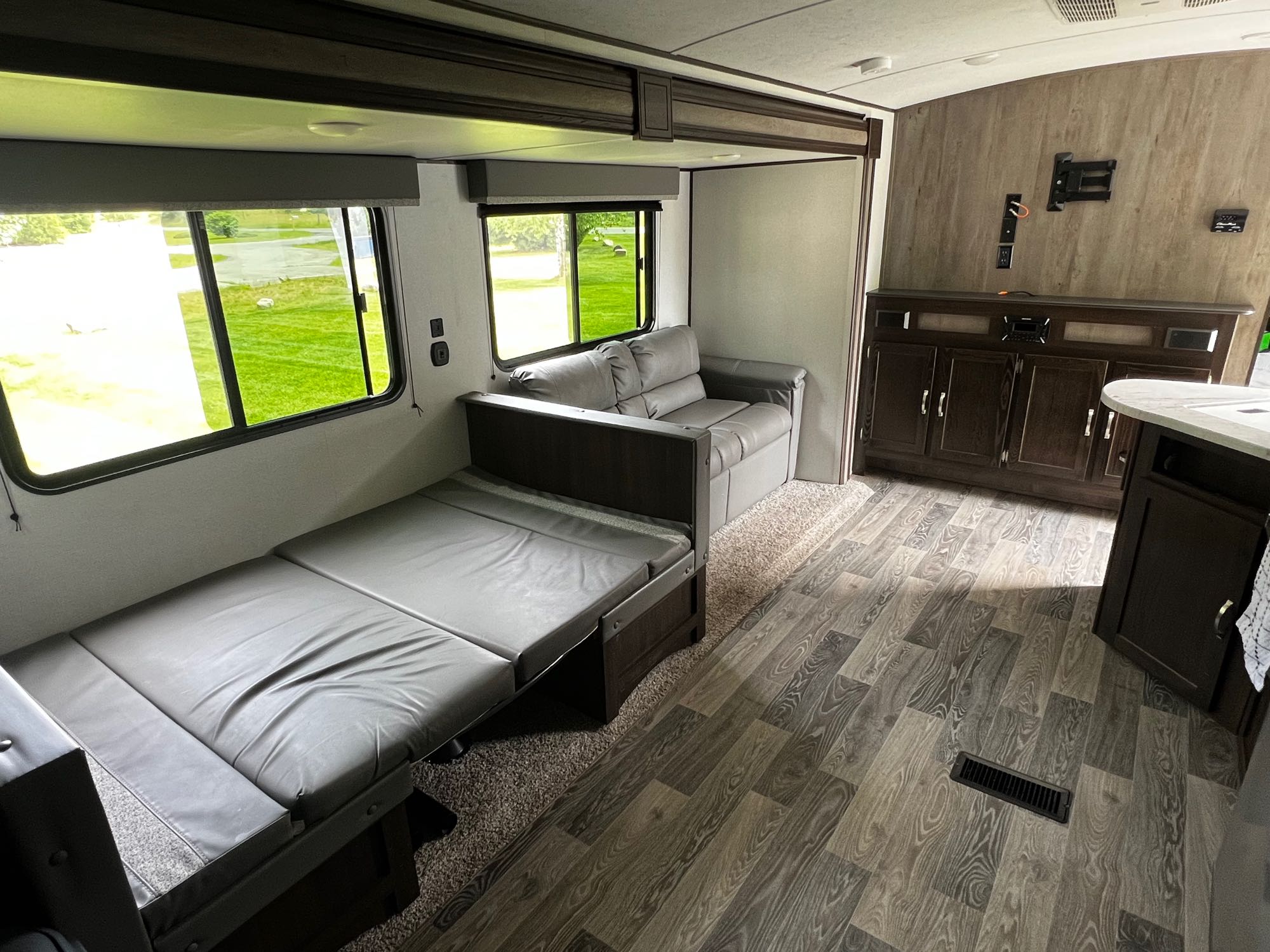 Enjoy this modern RV rental interior! Features include a convertible bed, comfy seating, storage, and scenic window views.. Keystone RV Springdale 2021