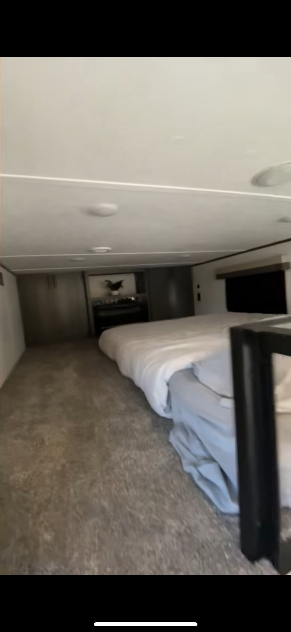 Cozy RV rental bedroom interior with a comfortable bed, carpeted floor, and built-in cabinets.. Dutchmen Colorado 2024