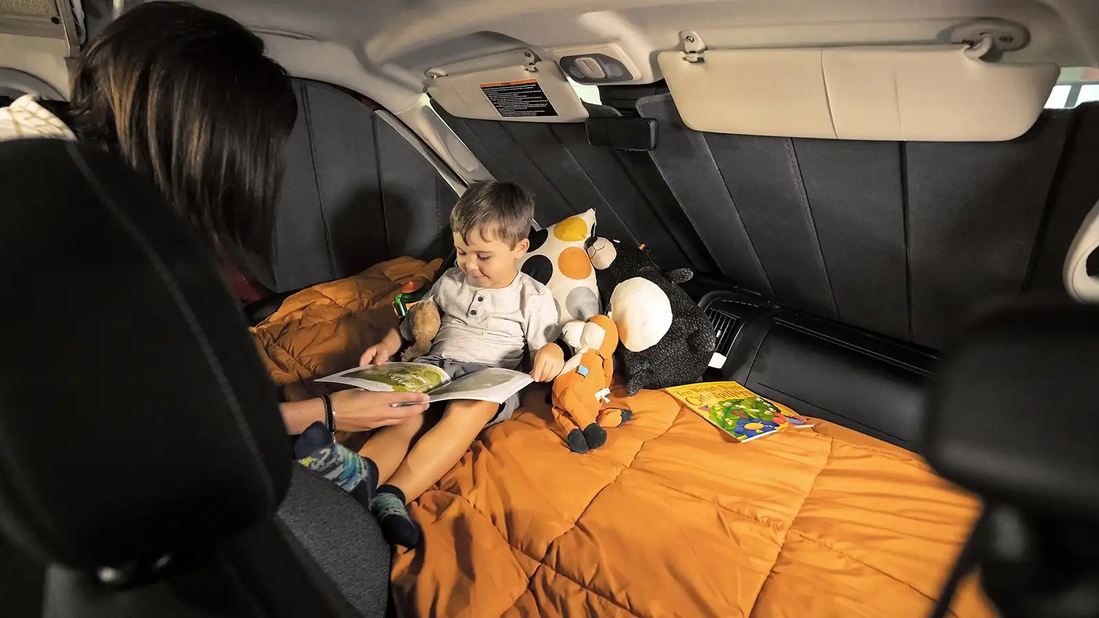 Mom reads to her son in a cozy RV rental setup, perfect for family camping and travel adventures.. Winnebago Solis 2021