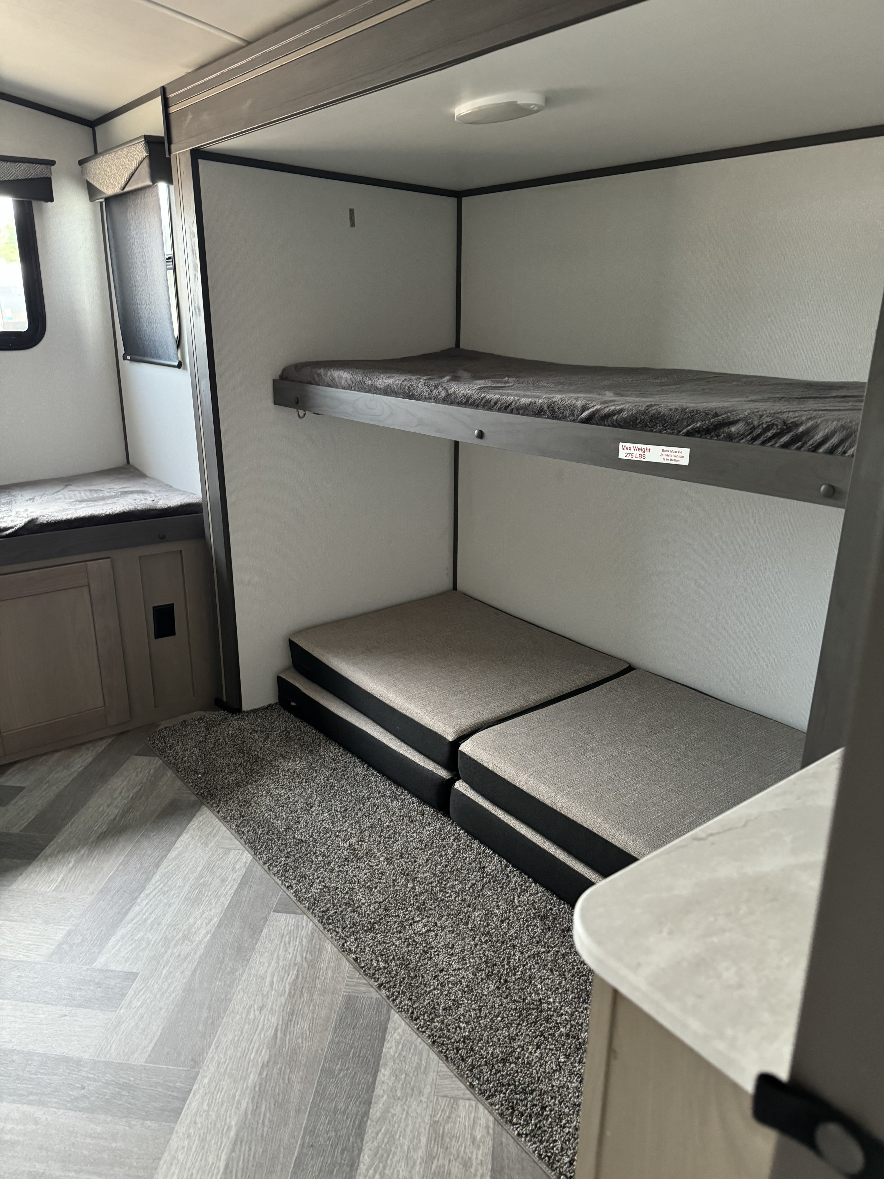 Cozy RV rental interior featuring a bunk bed, versatile floor cushions, and durable flooring for travel comfort.. Heartland Other 2021