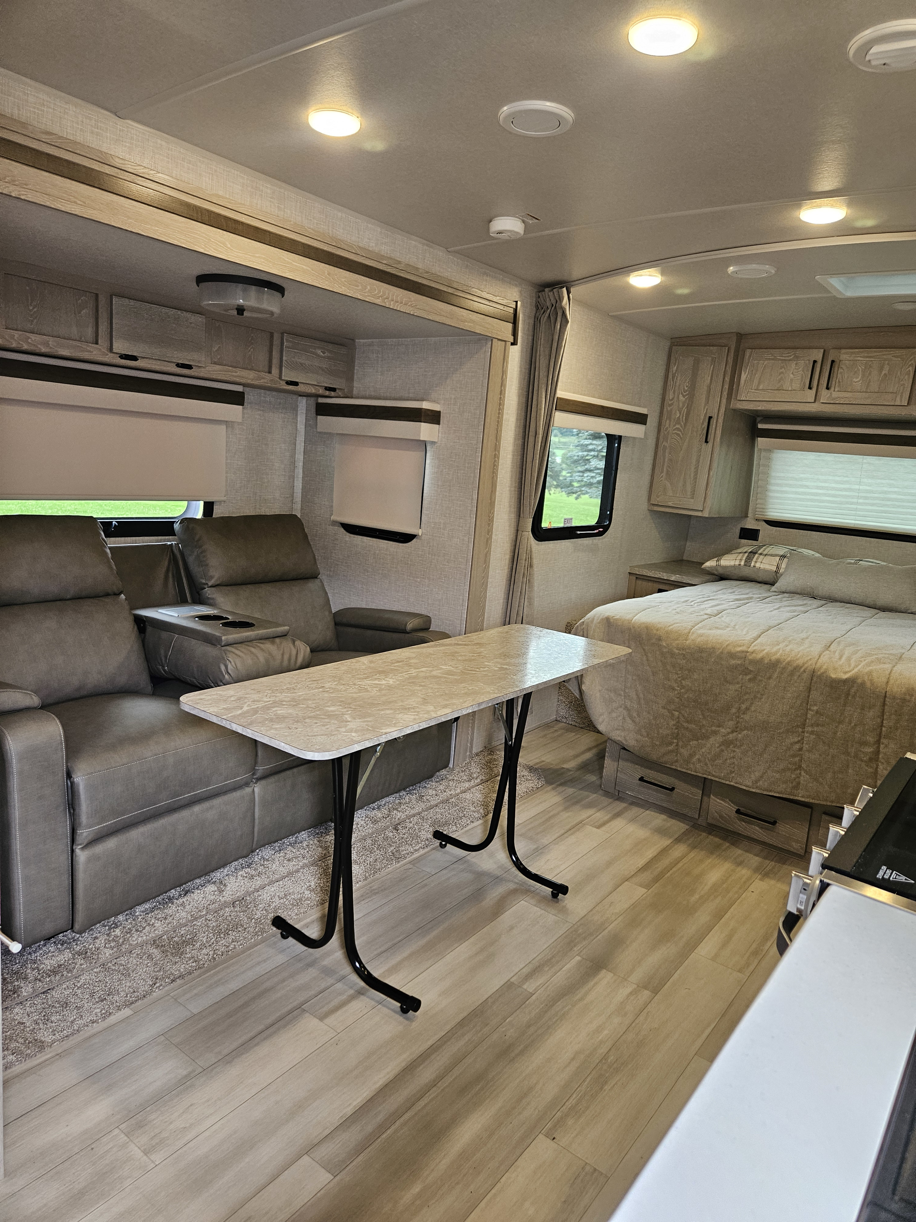 Comfortable RV rental interior with plush recliners, a functional table, and a cozy bed. Enjoy your travels.. Forest River Mini-Lite 2022