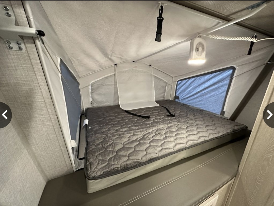 RV rental: Inside a pop-up camper's comfortable sleeping area with bed, fabric walls, and fan.. Forest River Flagstaff Shamrock 2020