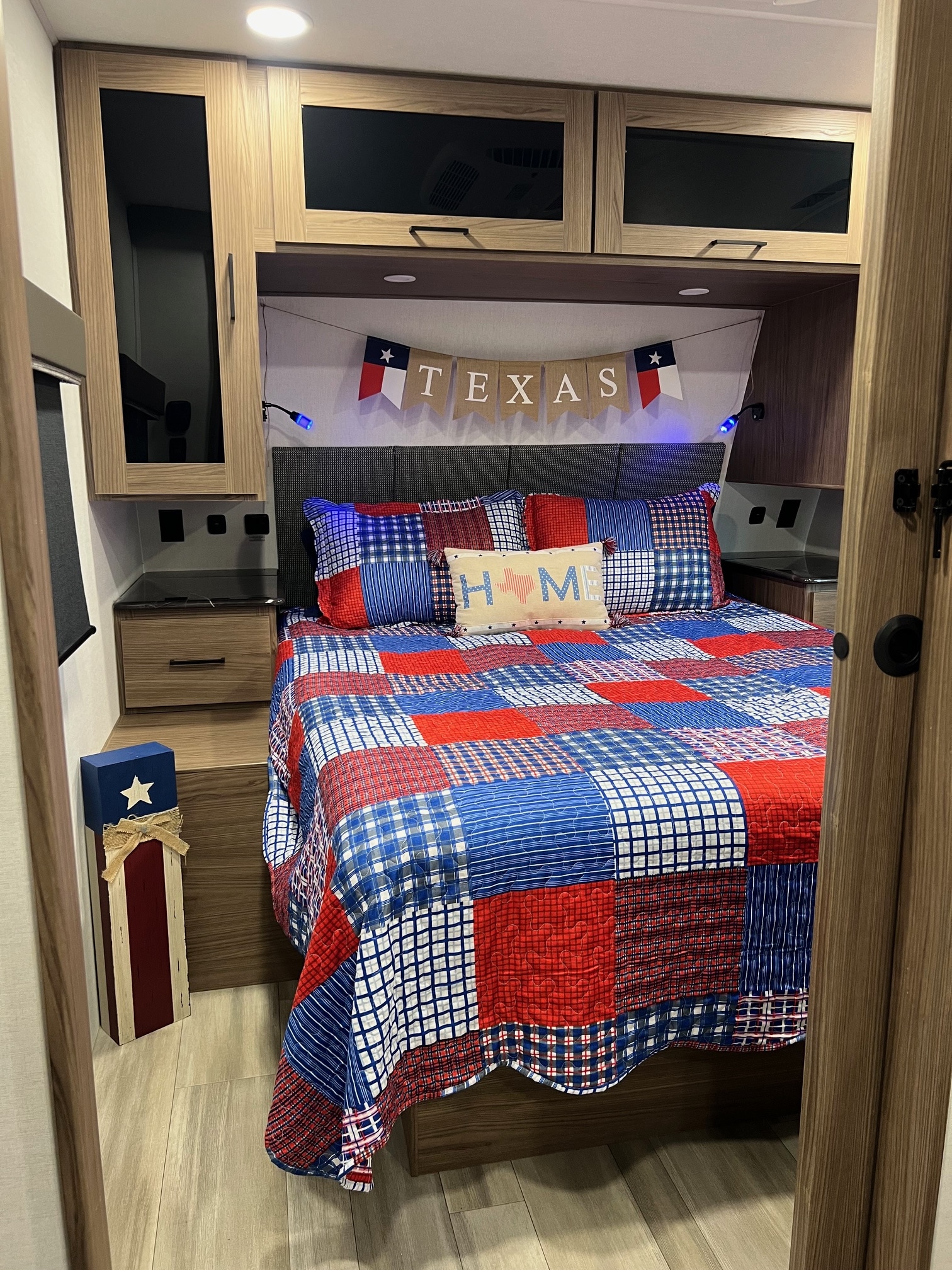 Cozy RV rental bedroom with patriotic Texas decor, patchwork quilt, and built-in storage. Ideal for travel.. Alliance Delta 251BH 2024