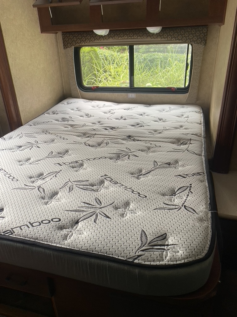 Cozy RV rental bedroom featuring a clean iBamboo mattress, with a view of nature outside.. Forest River Sunseeker 2014