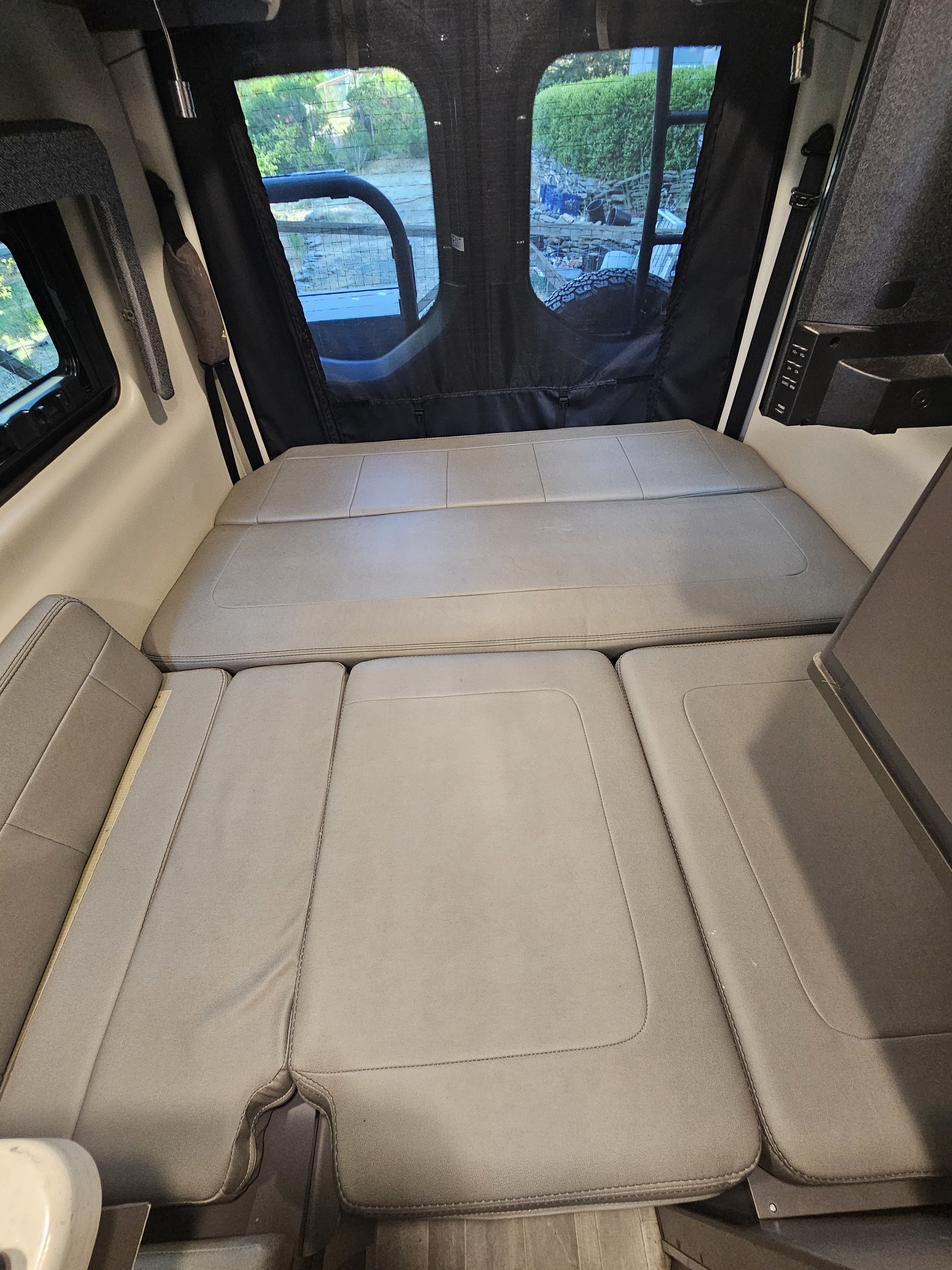 Comfortable RV rental interior featuring convertible seating for a full bed, ideal for road trips.. Thor Motor Coach Sanctuary 2023