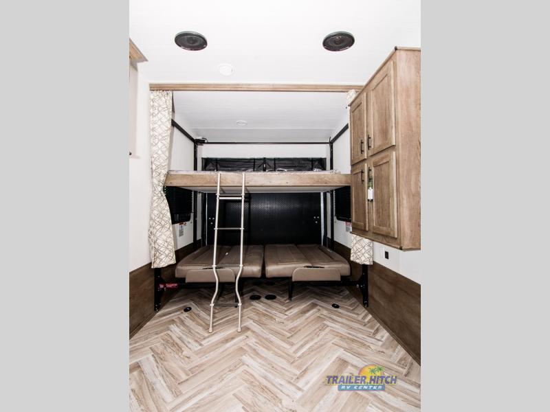 Experience comfortable RV rental living with this toy hauler's versatile bunk bed and seating area, perfect for adventurers.. Forest River Stealth 2020