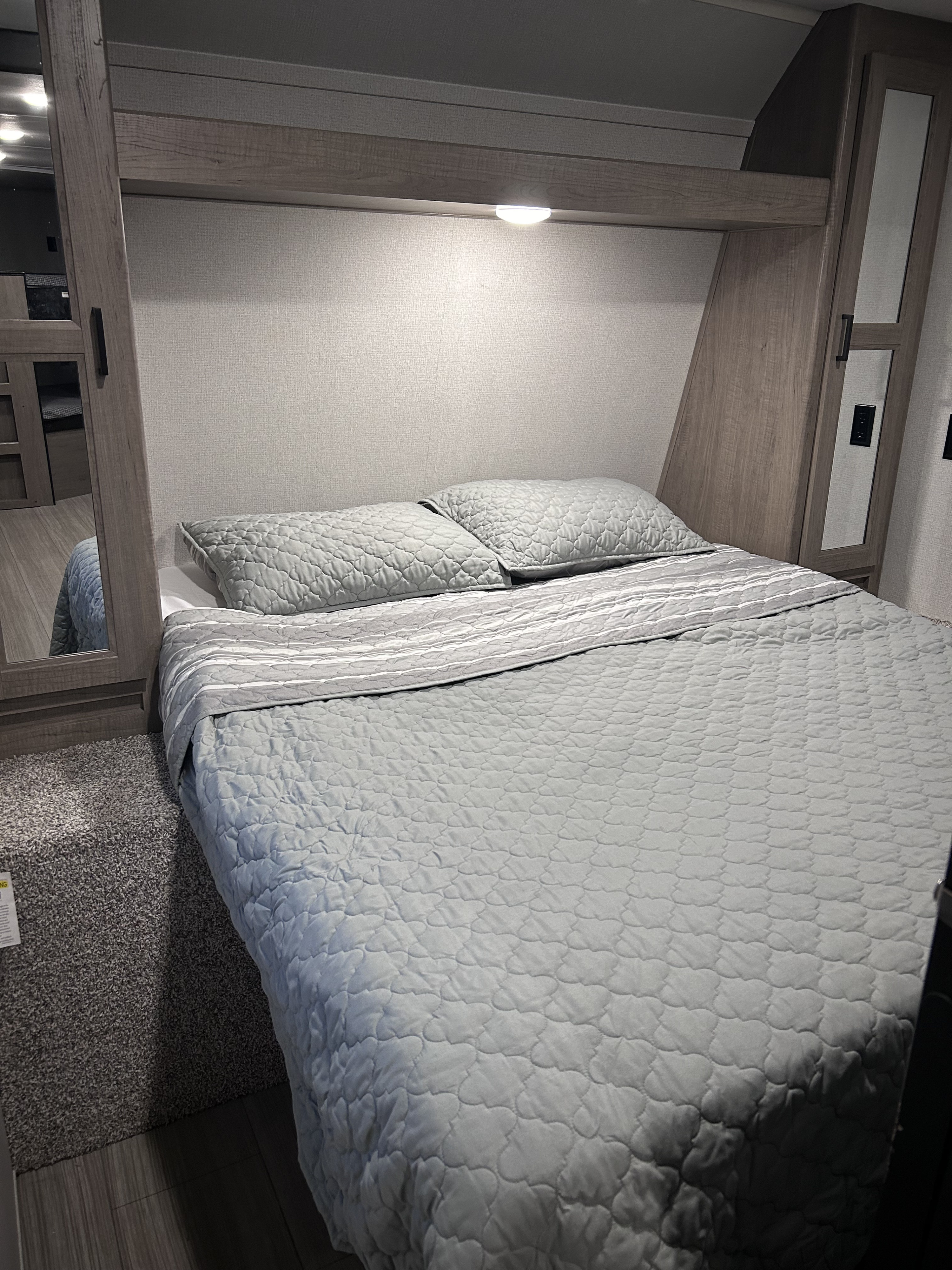 Comfortable RV bedroom for your next RV rental. Features a spacious bed, overhead lighting, and built-in storage.. Keystone RV Hideout 2021