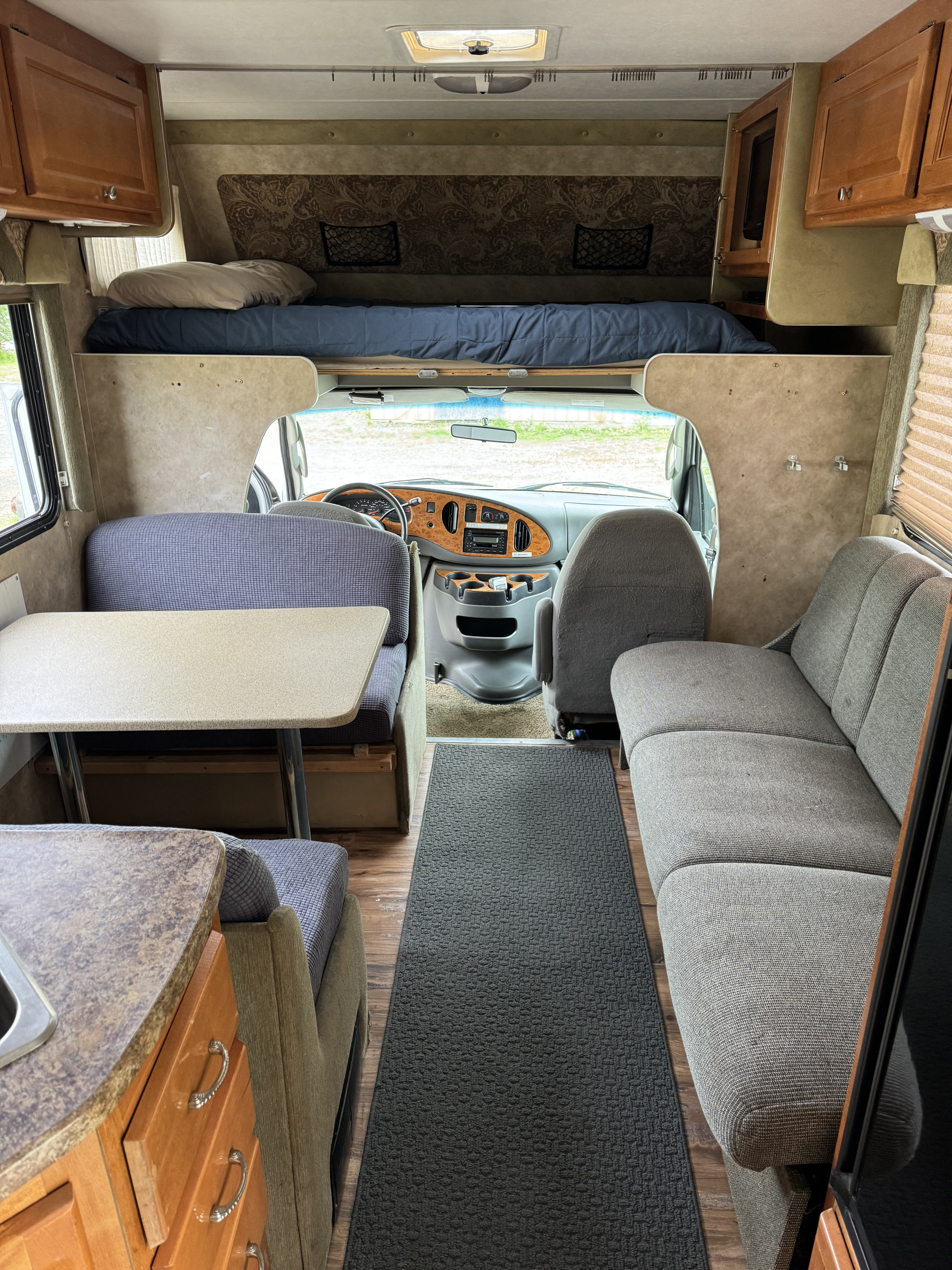 Inside a clean RV rental: bunk over cab, dinette with table, and a comfy couch with galley area.. Gulf Stream Yellowstone 2008