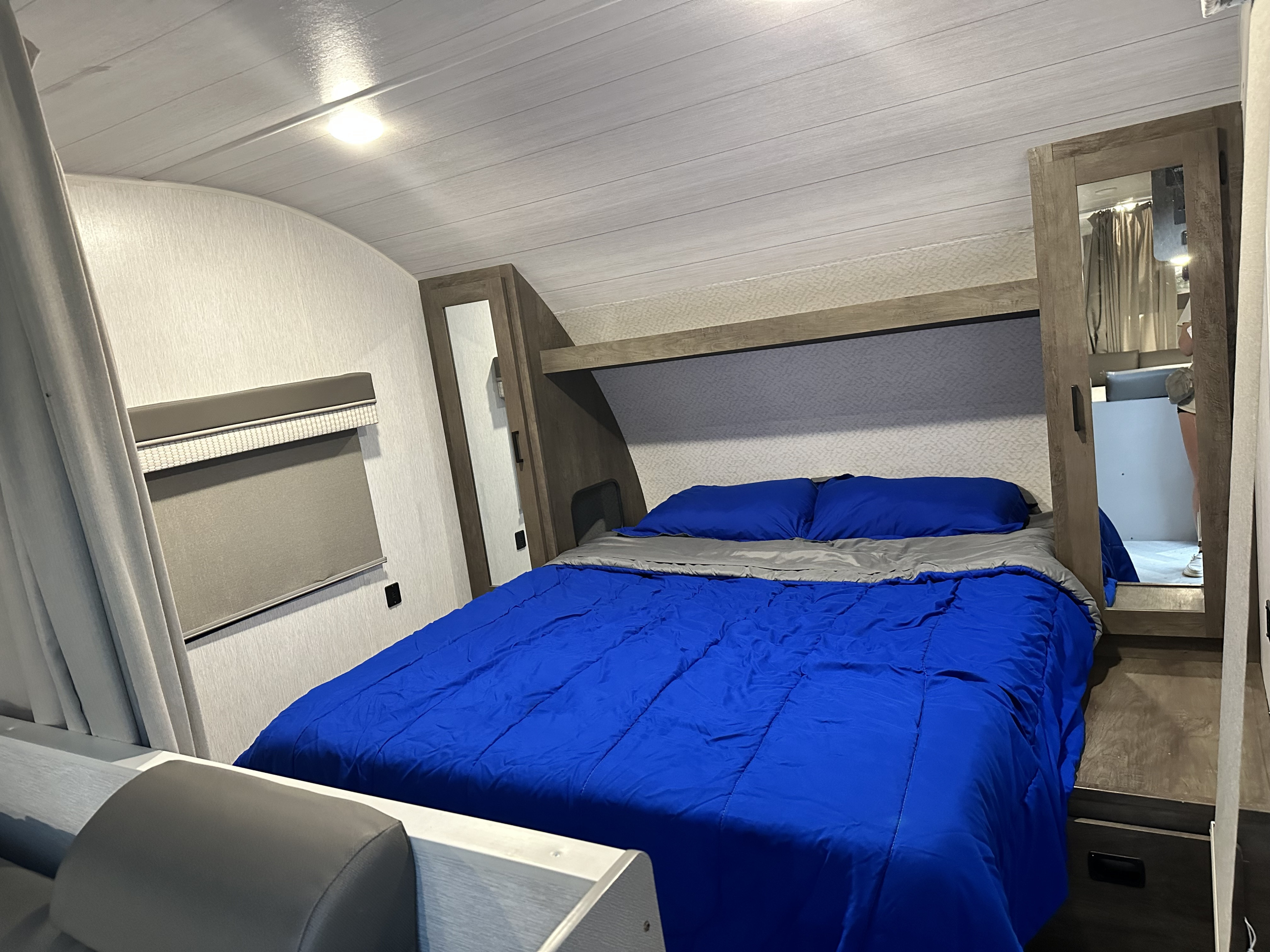 Inside this RV rental: a dinette area with a table & benches, overhead cabinets, bunk bed, and open entry door.. Forest River Salem Cruise Lite 2023