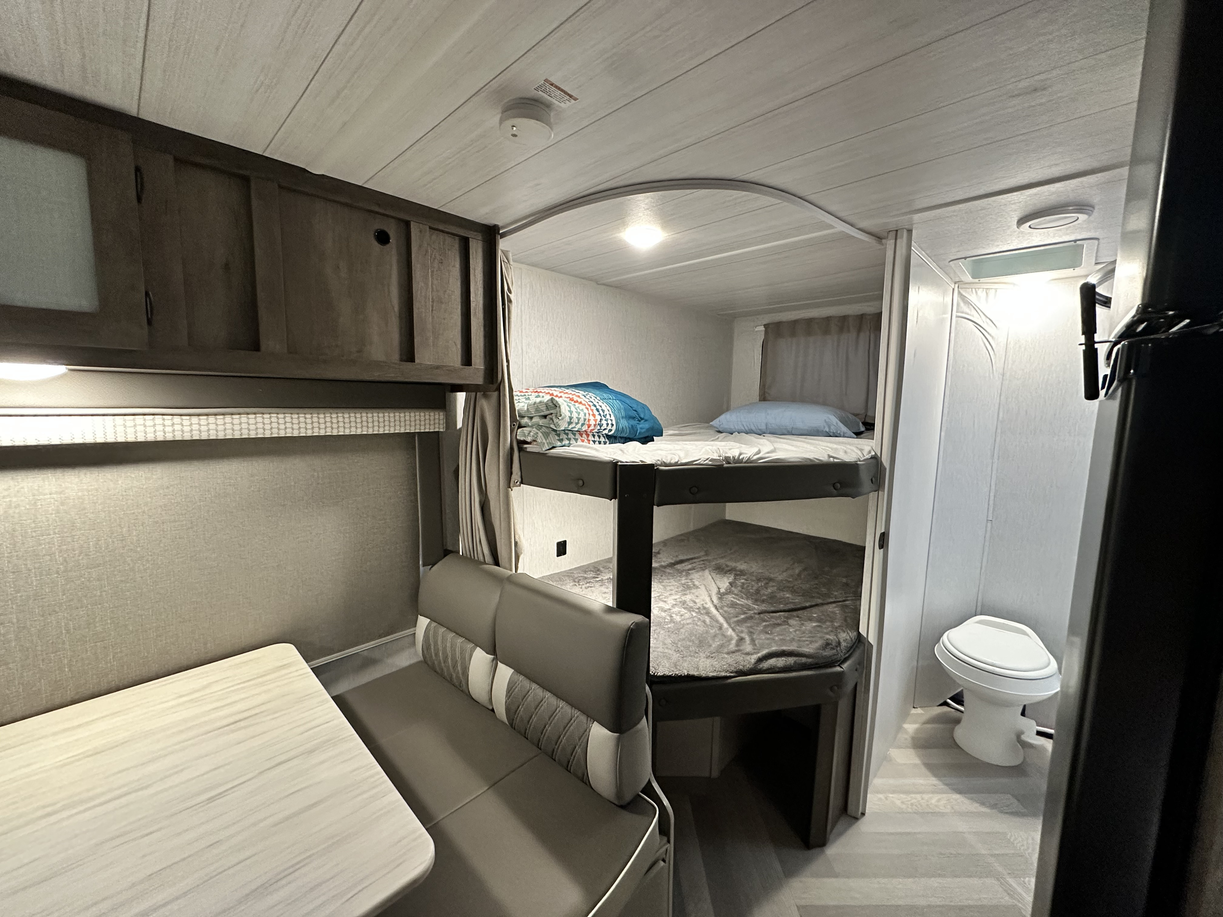 RV rental interior features bunk beds, a dinette, and a compact bathroom, ideal for family travel.. Forest River Salem Cruise Lite 2023