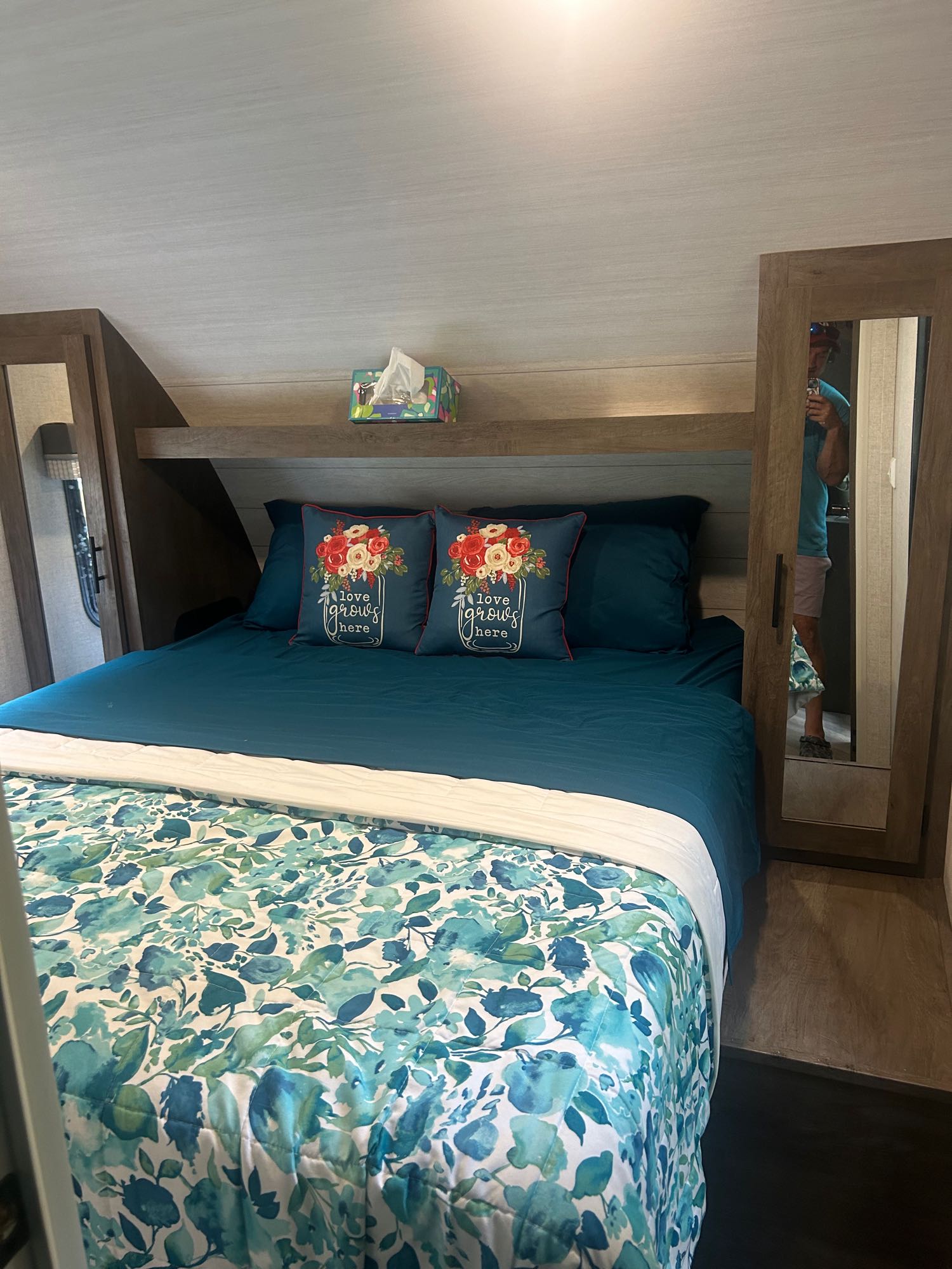 Cozy RV rental bedroom with a large bed, teal sheets, and a white & blue floral comforter. Mirrored wardrobes are on both sides.. Forest River Salem Cruise Lite 2021