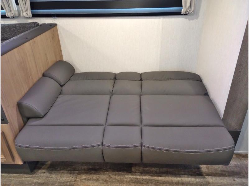 Comfortable gray modular sofa bed inside an RV rental, ideal for versatile seating and sleeping arrangements.. Forest River Cherokee Grey Wolf 2024