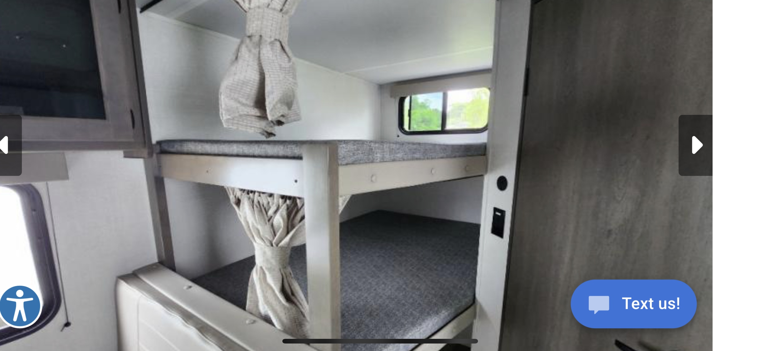 Experience comfort in this RV rental! The interior shows bunk beds with grey mattresses, tied-back privacy curtains, and a window view.. Grand Design Transcend Xplor 2024