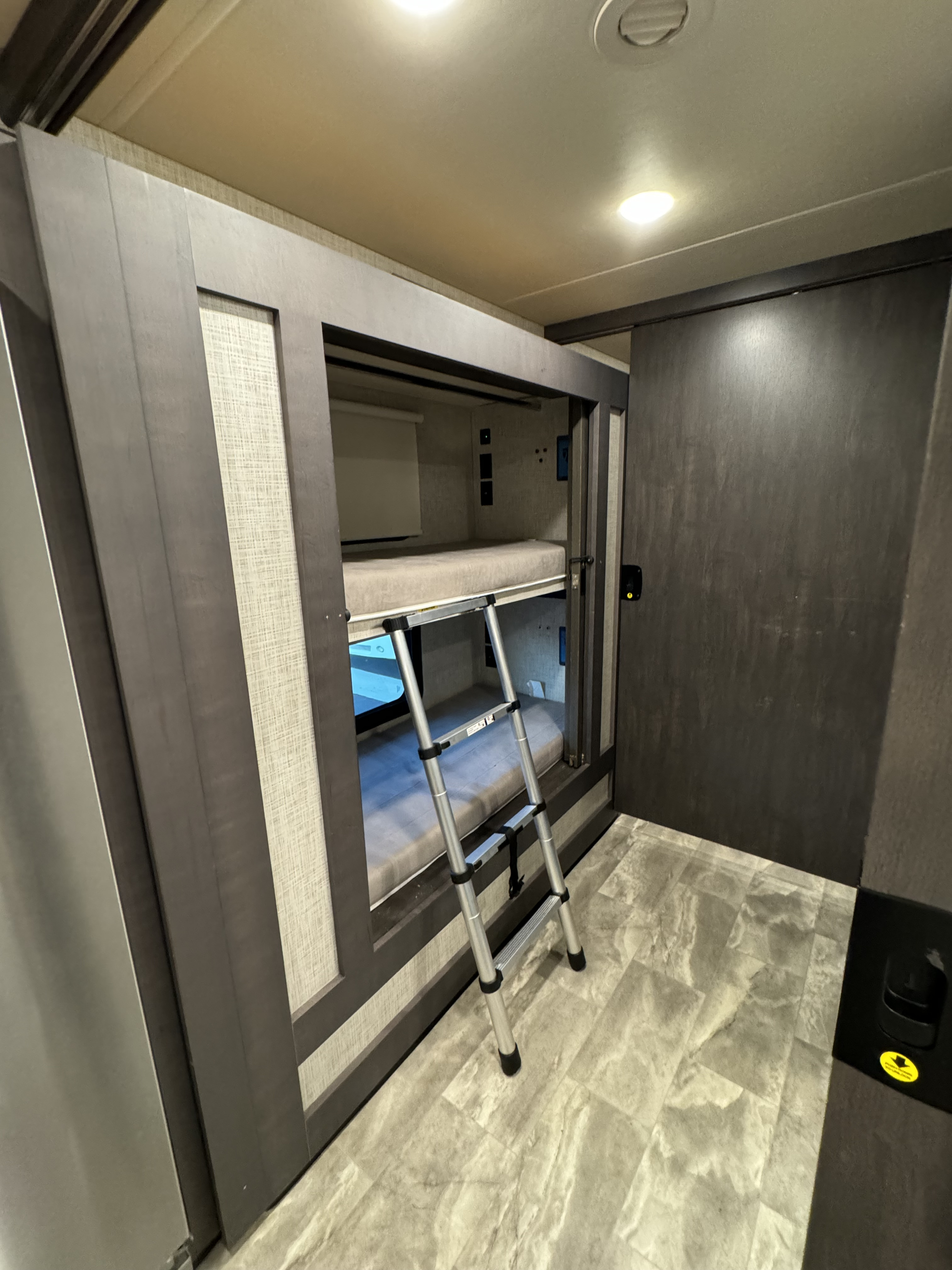 Modern RV rental interior: comfortable bunk beds with a ladder, ideal for camper family travel.. Thor Motor Coach CHALLENGER 37DS 2023