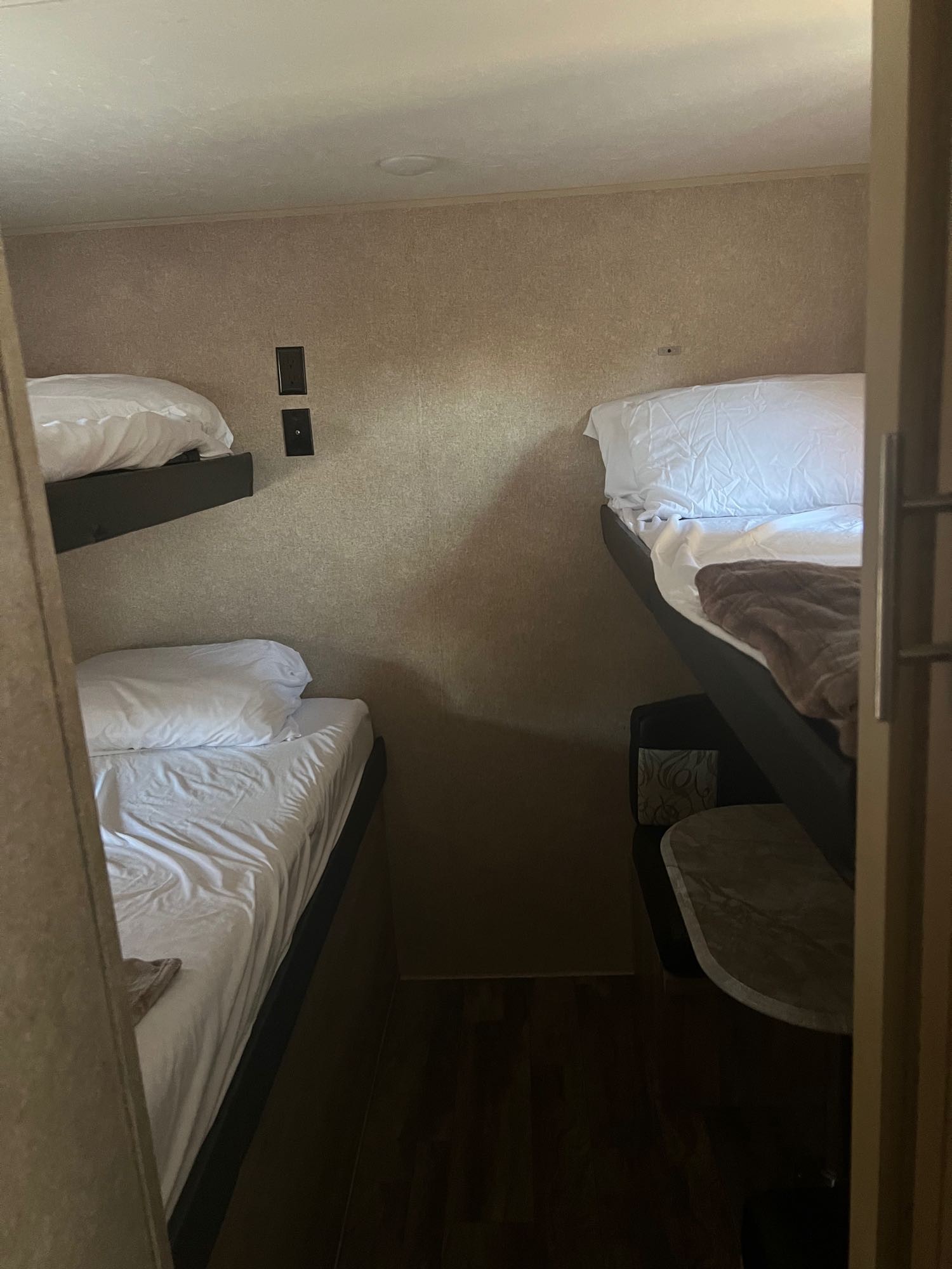 Compact RV rental sleeping area featuring comfortable bunk beds with white linens, ideal for travelers.. Forest River Coachmen Catalina SBX 2019
