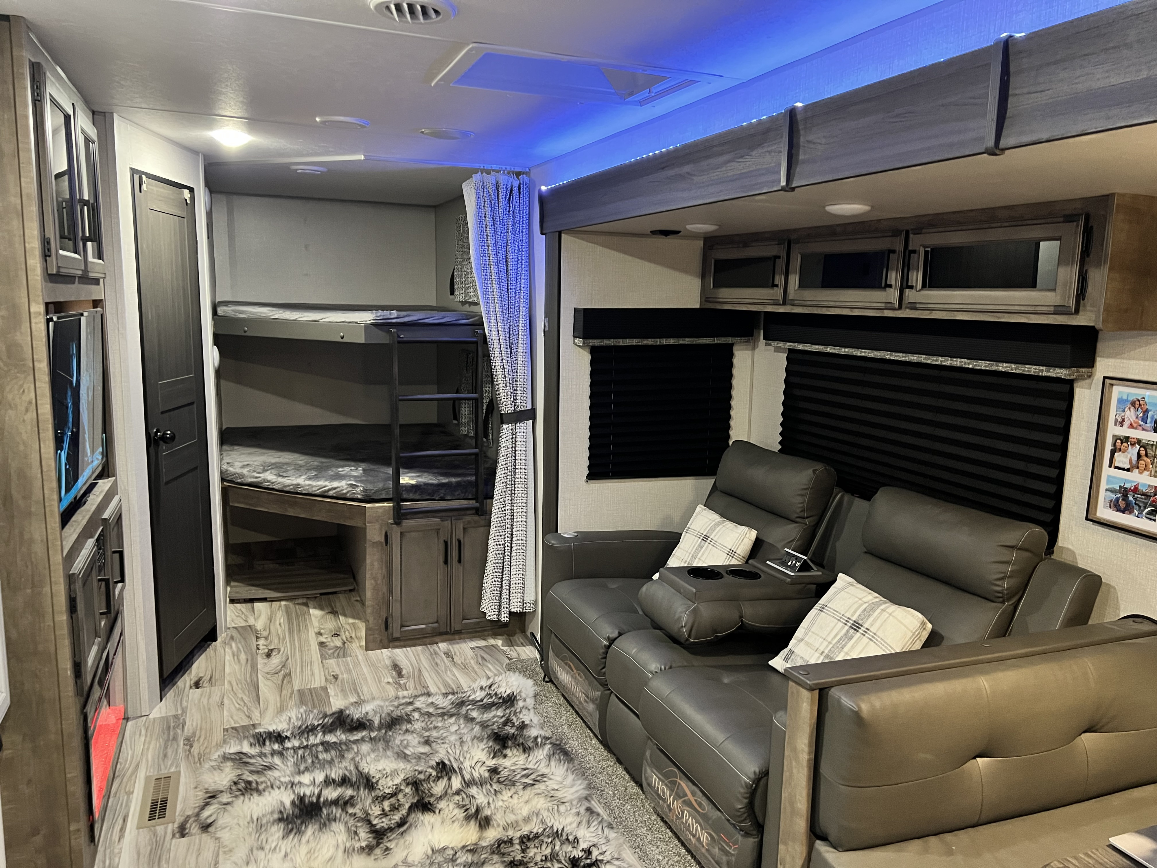 Modern RV rental interior: Features comfy recliners, bunk beds, storage, and blue LED accent lighting for travel.. Venture SportTrek Touring Edition STT312VBH 2021