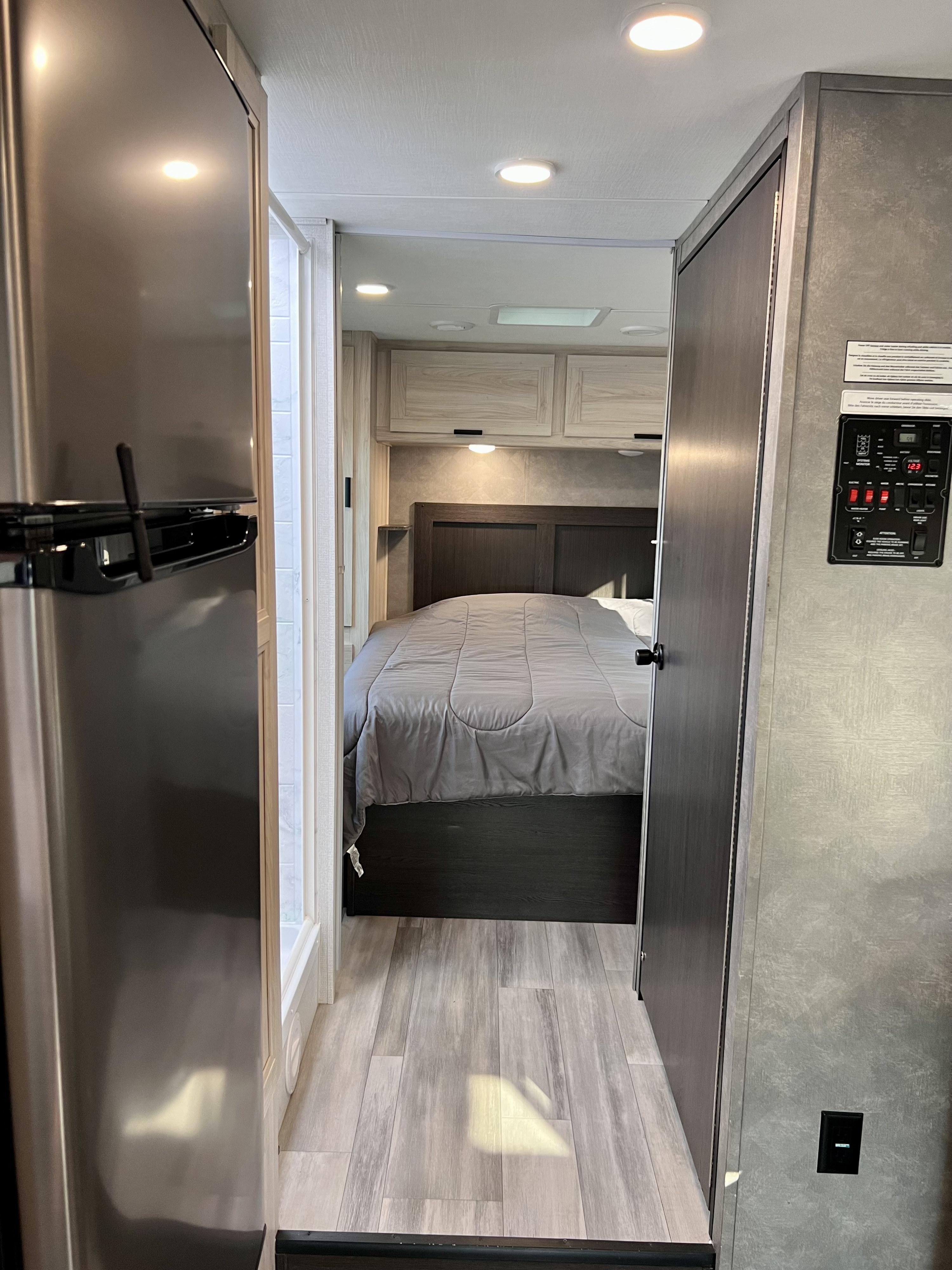 Explore this RV rental's cozy bedroom, sleek fridge, and smart control panel, showcasing a modern interior.. Forest River Forester 2023