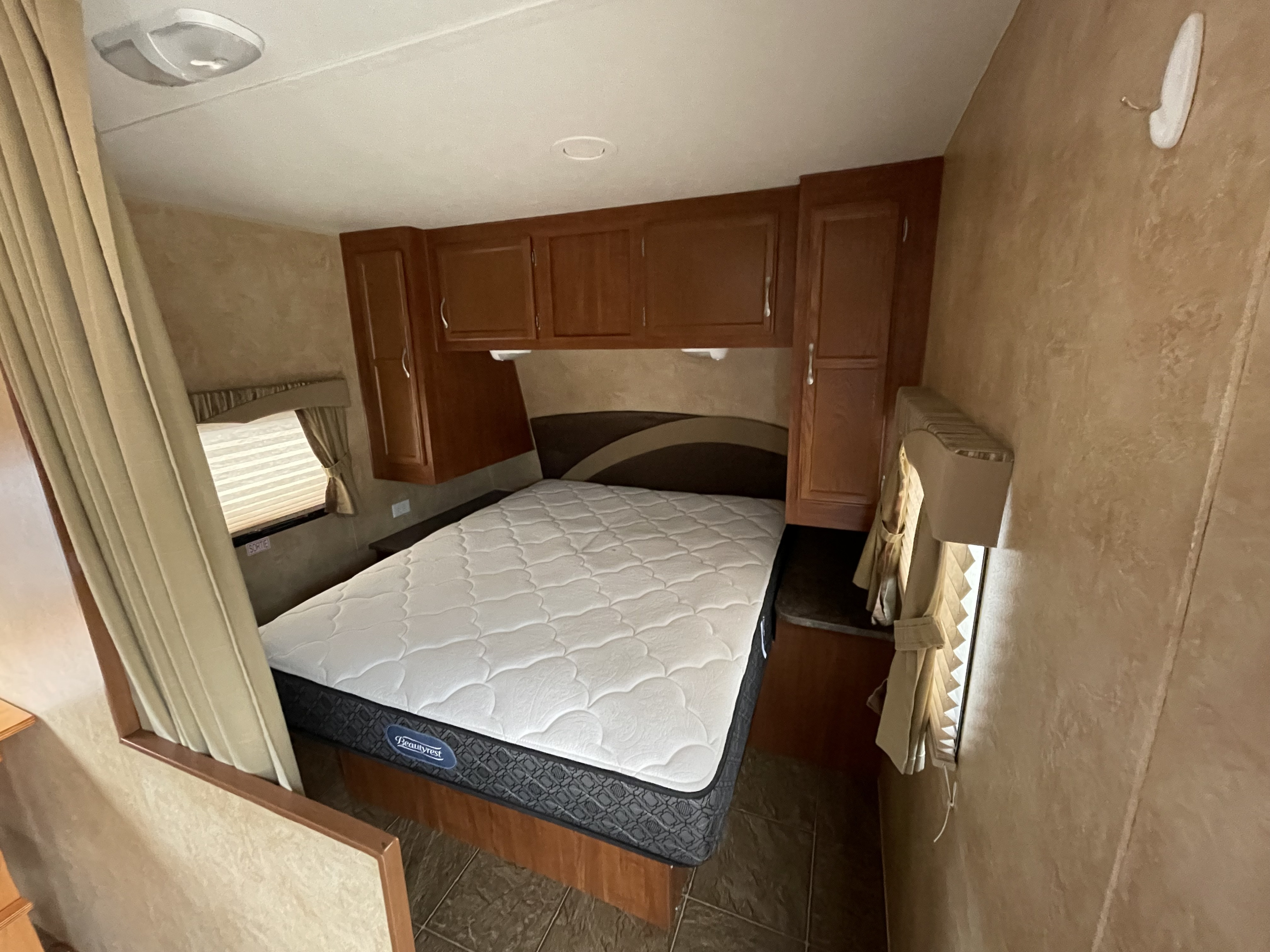 Comfortable RV rental bedroom with a Beautyrest mattress, overhead storage, and window. Perfect for your next adventure.. Jayco Jay Flight 2012