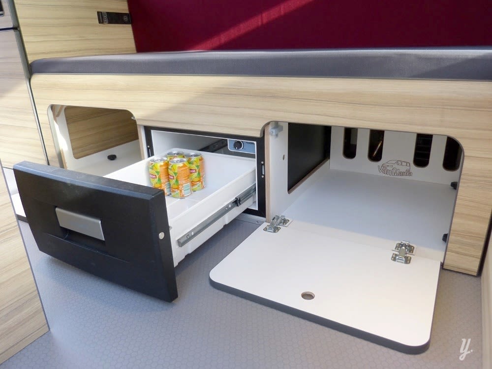 RV rental showing a compact interior with a pull-out drawer fridge for drinks and an open storage area.. opel L'OTAGO (Caen) 2024