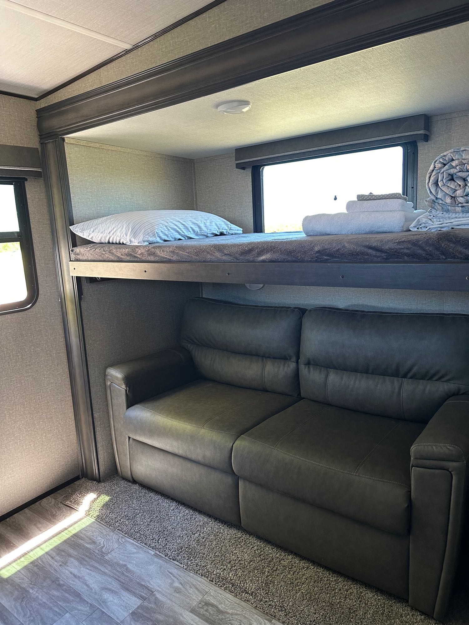 Experience comfort in this RV rental! Bunk bed over sofa, with a window and clean towels ready. Perfect for trips.. Grand Design Reflection 2021