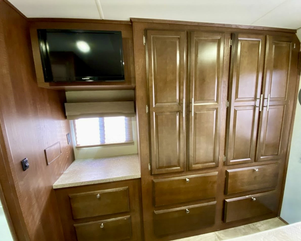 RV rental: Inside, find a wall-mounted TV, window with a blind, counter, and rich wood cabinets/drawers for storage.. Georgetown GT3 2017