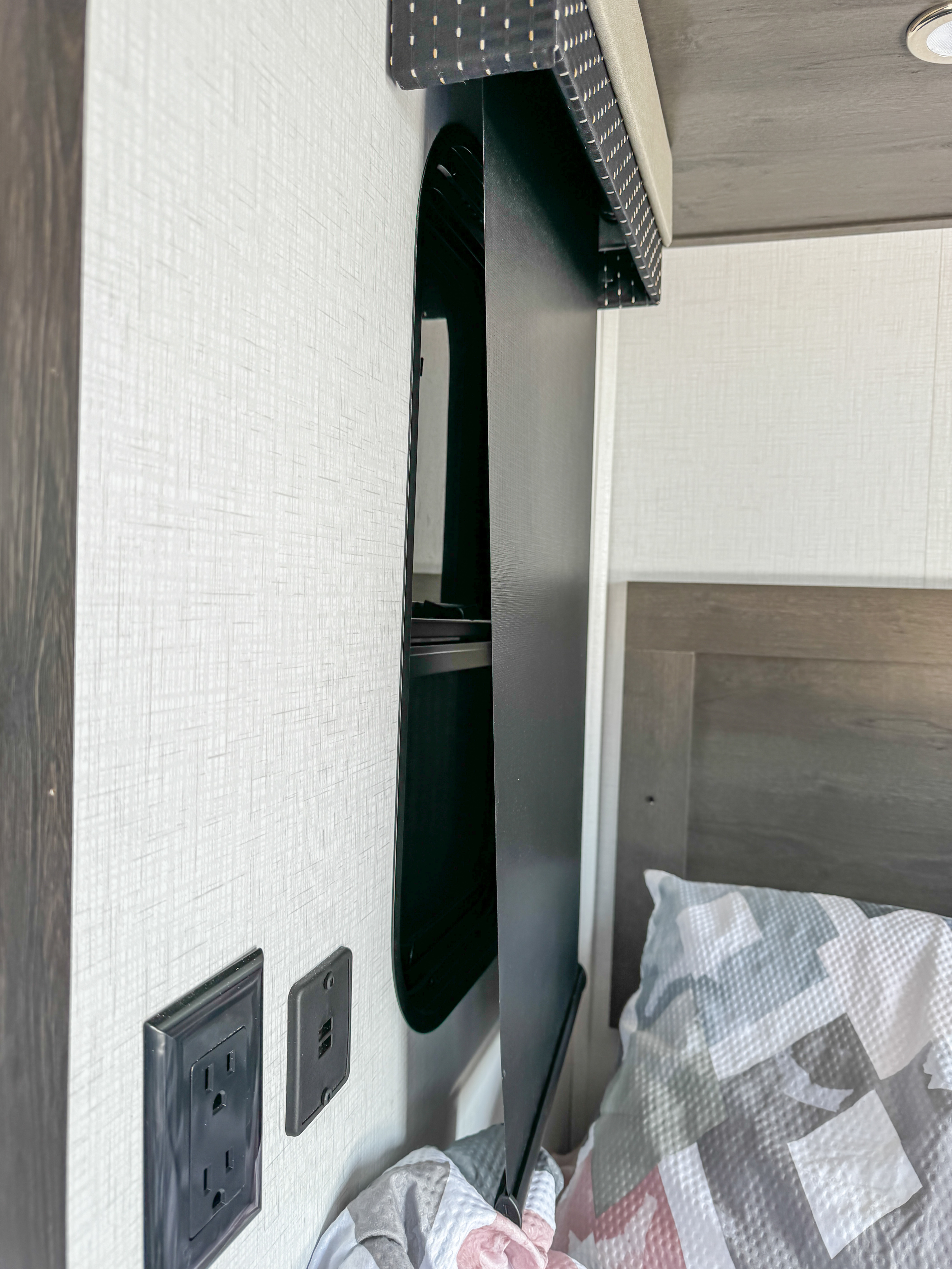 RV rental bedroom with bed, white textured wall, power outlets, USB port, and a narrow wall-mounted storage unit.. FR3 FR3 Motorhome 2023