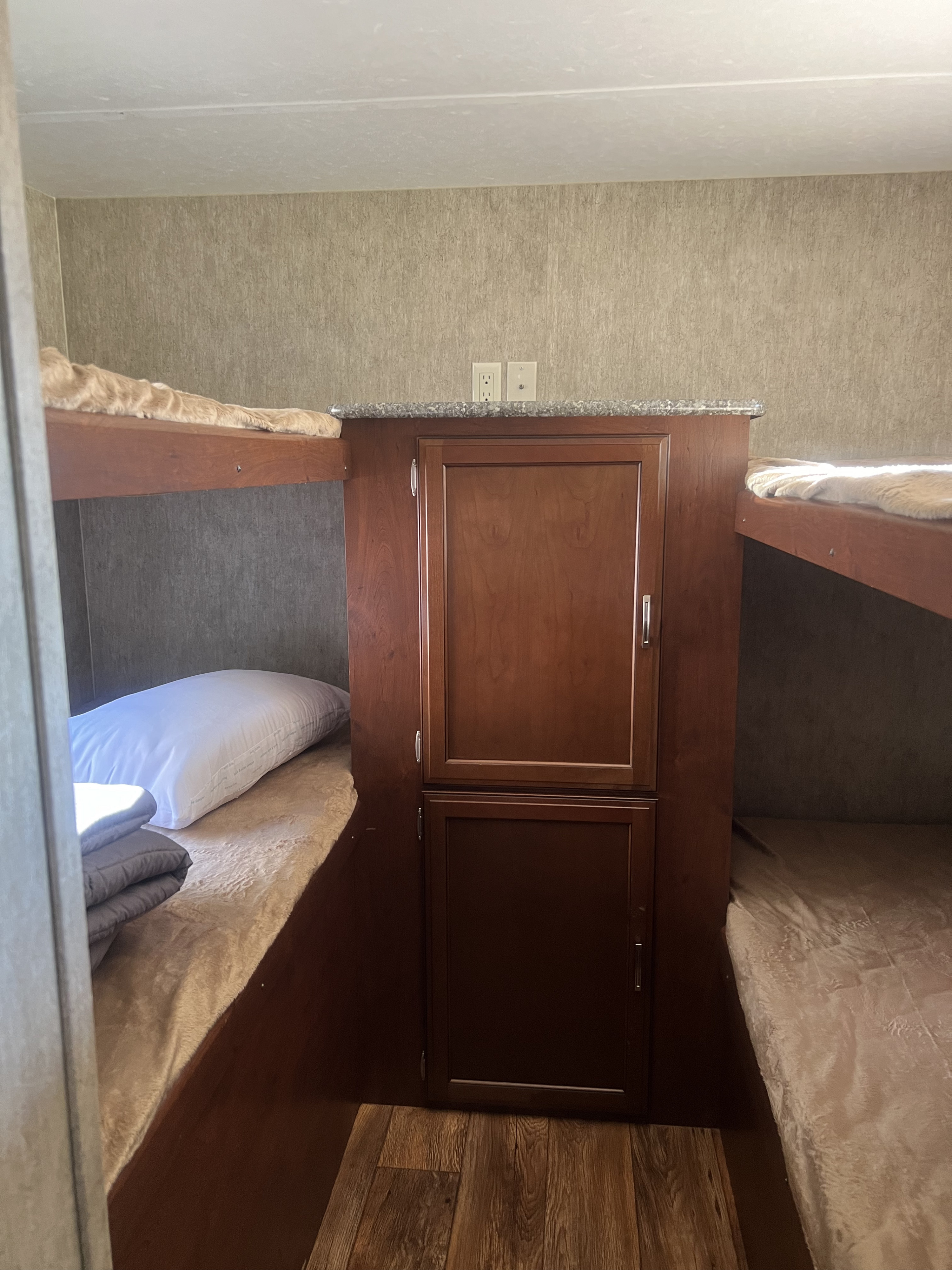 Cozy RV rental bunk beds with built-in storage, perfect for a comfortable sleeping area.. Keystone RV Passport Grand Touring 2015