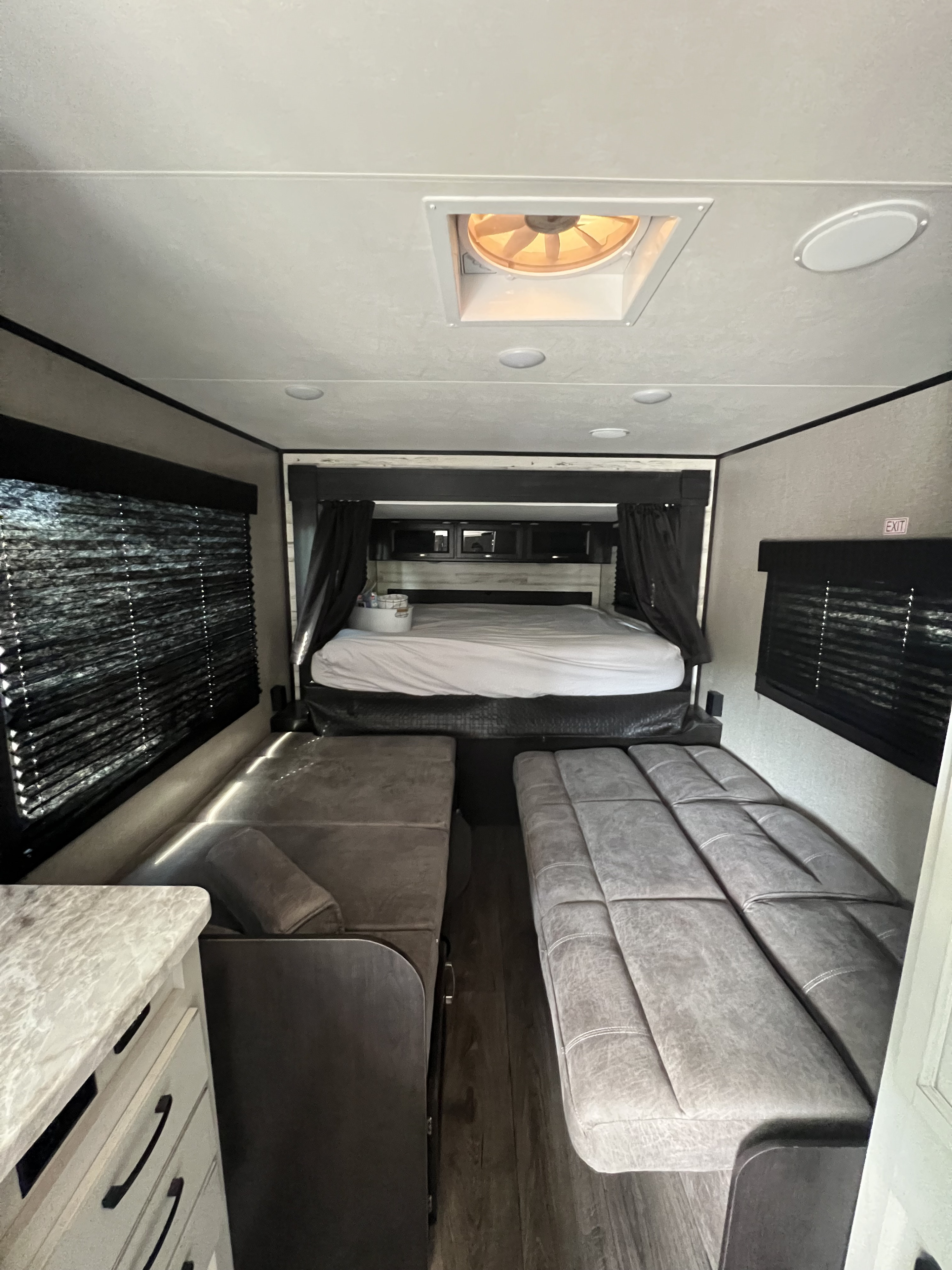 RV rental interior: A spacious camper bedroom with bed, convertible benches, and side counter.. Jayco Jay Feather 2021