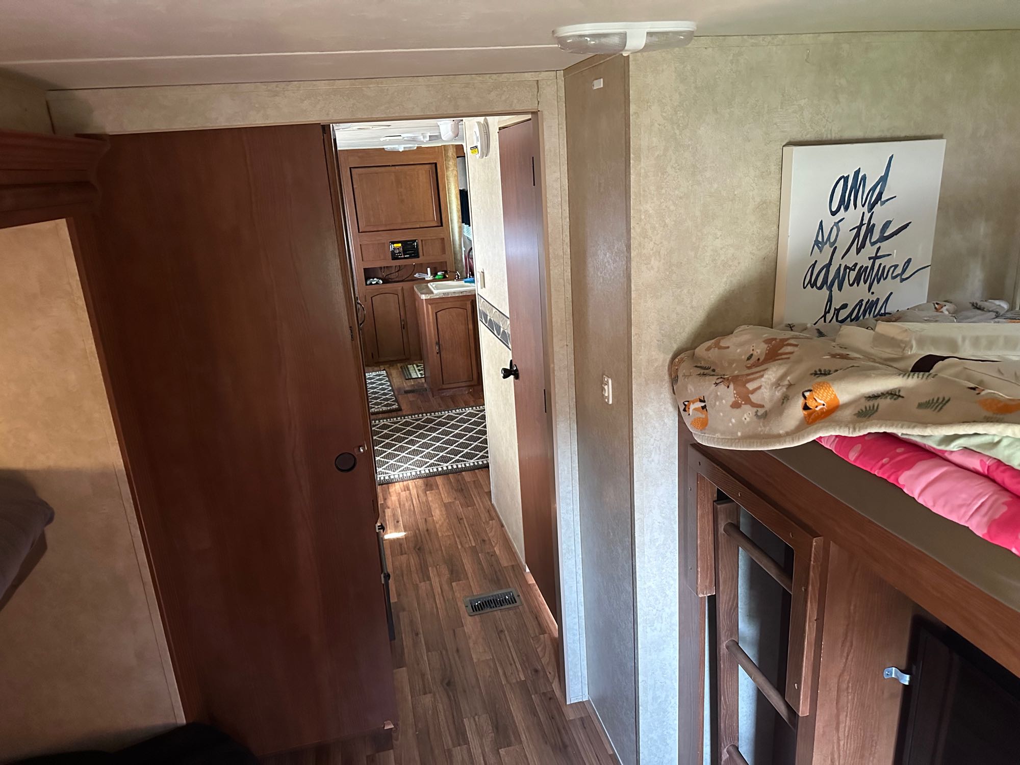 Spacious RV rental interior featuring a hallway, kitchen, and cozy bunk beds. Ready for your adventure!. Forest River Wildwood 2012
