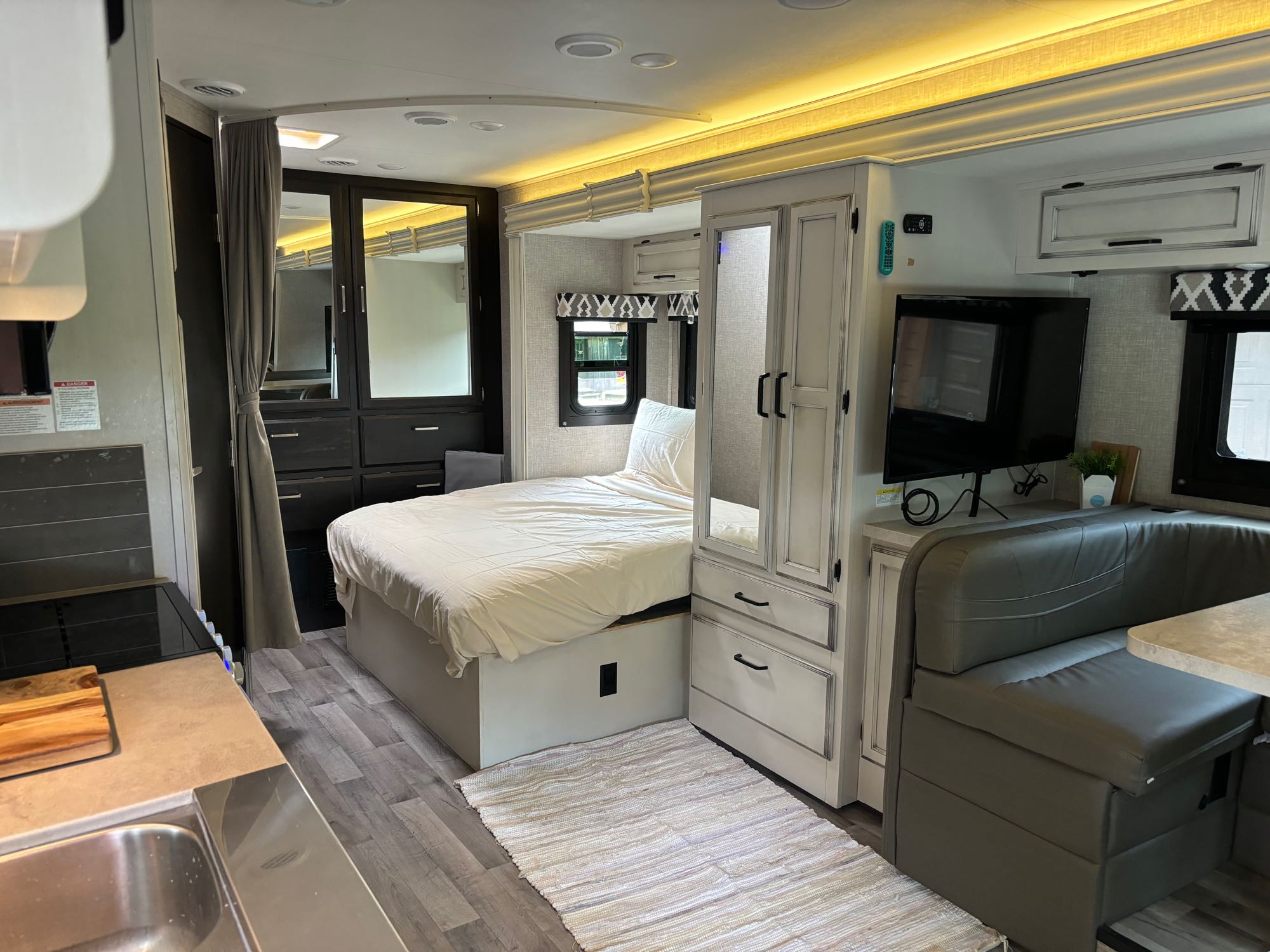 Modern rv rental interior with bed, kitchen, TV, and dinette. A cozy, functional living space.. Jayco Redhawk SE 2022