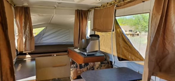 Discover this pop-up RV rental interior: comfy bed, compact kitchen, and living space for camping.. Jayco Jay 2013