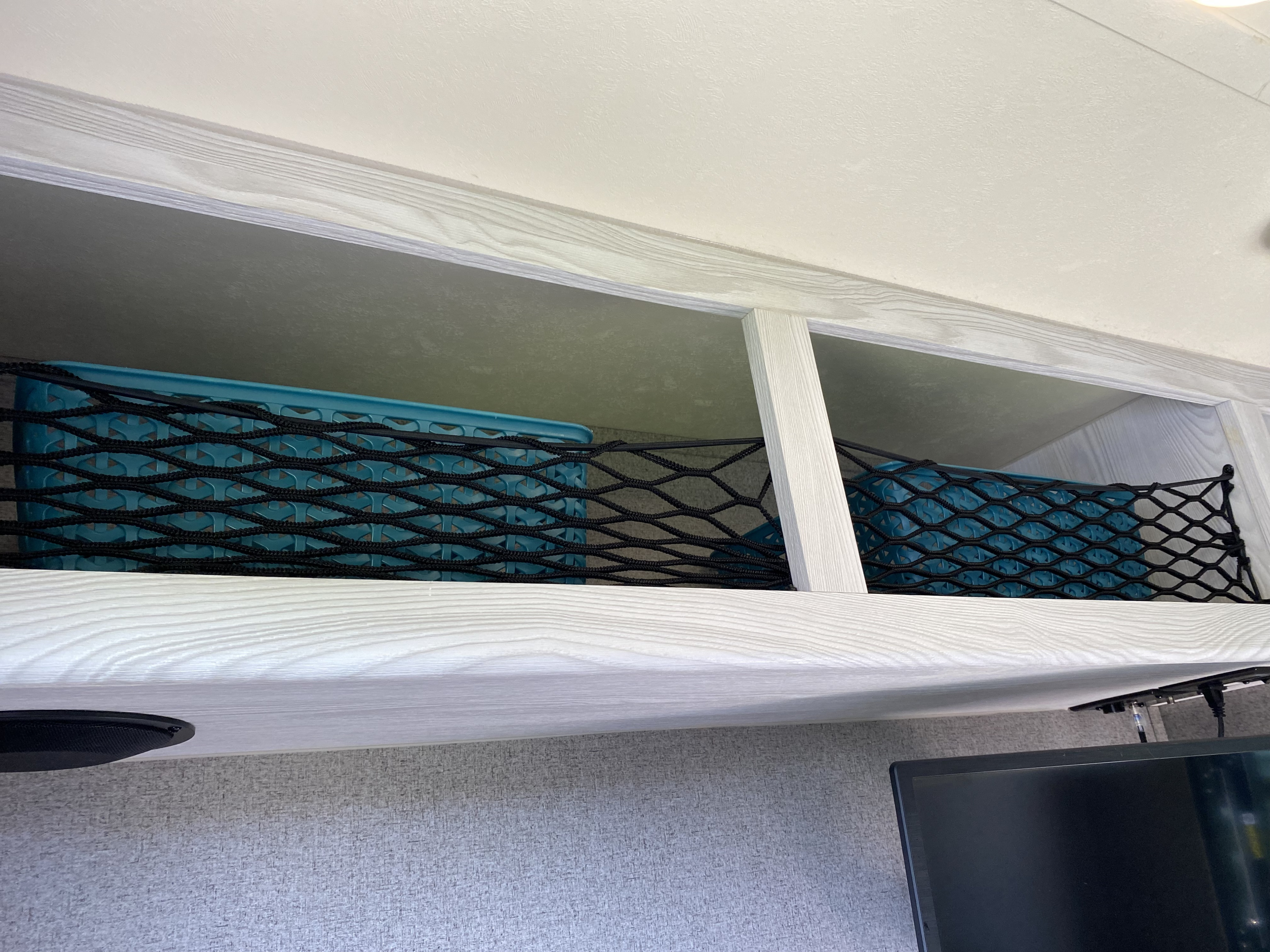 RV rental: Secure overhead storage in this RV, featuring blue bins and a black mesh net for organizing items.. Forest River Flagstaff E-Pro 2018