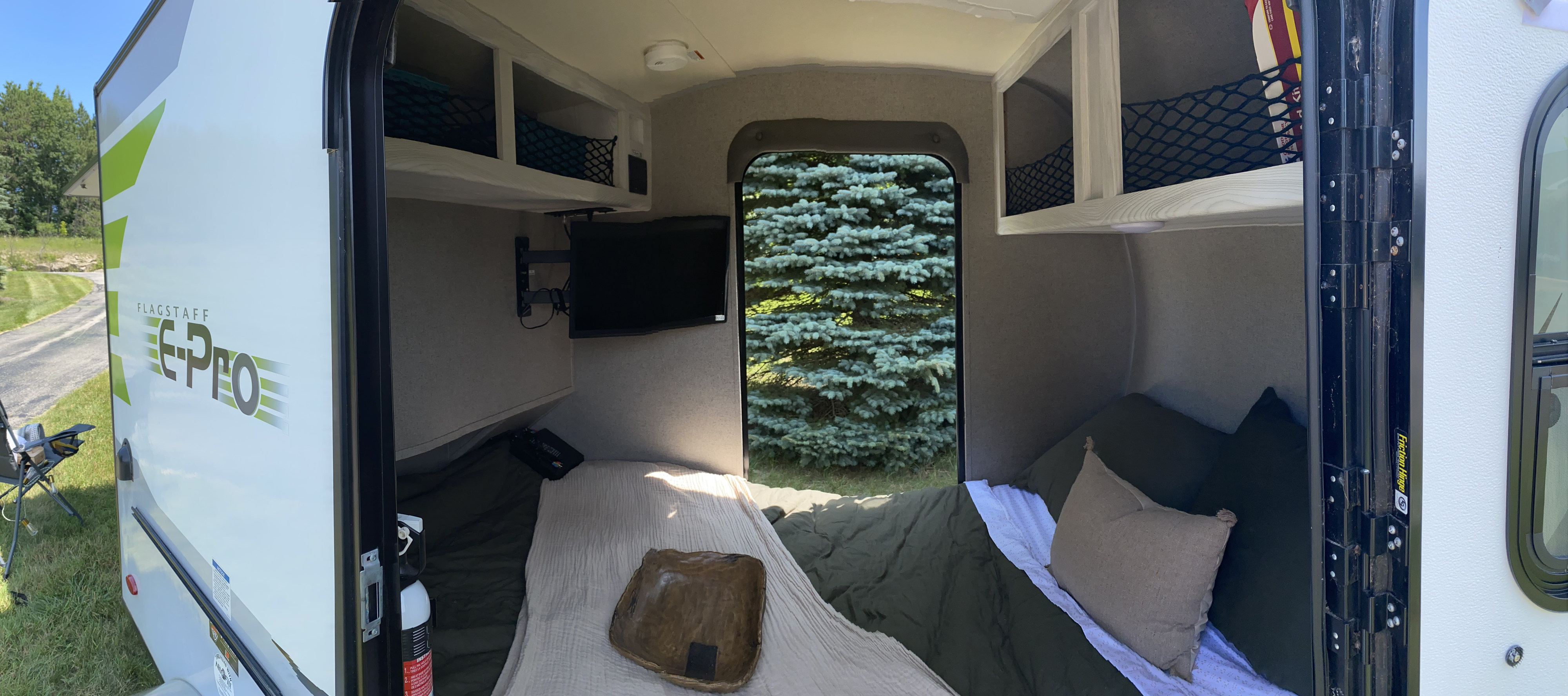 Cozy Flagstaff E-Pro RV rental interior with bed, TV, and storage visible. Perfect for compact camper adventures.. Forest River Flagstaff E-Pro 2018