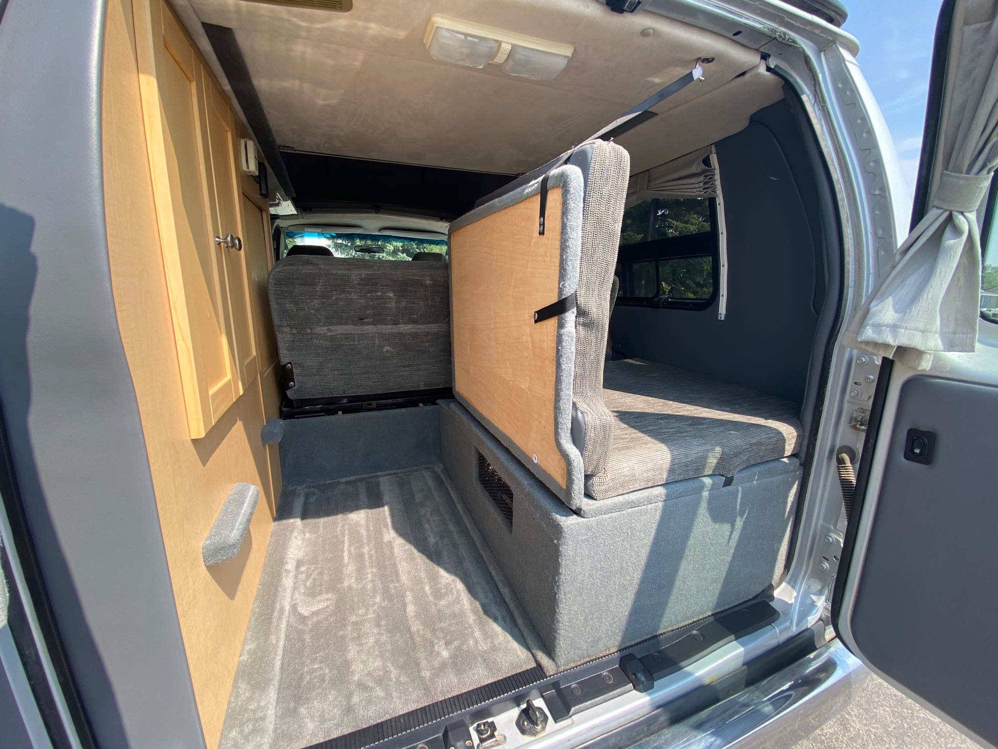 Spacious RV rental interior featuring versatile seating/bed conversion, built-in cabinets, and carpeted flooring.. Pleasure-Way Pleasure-Way Class B 2007