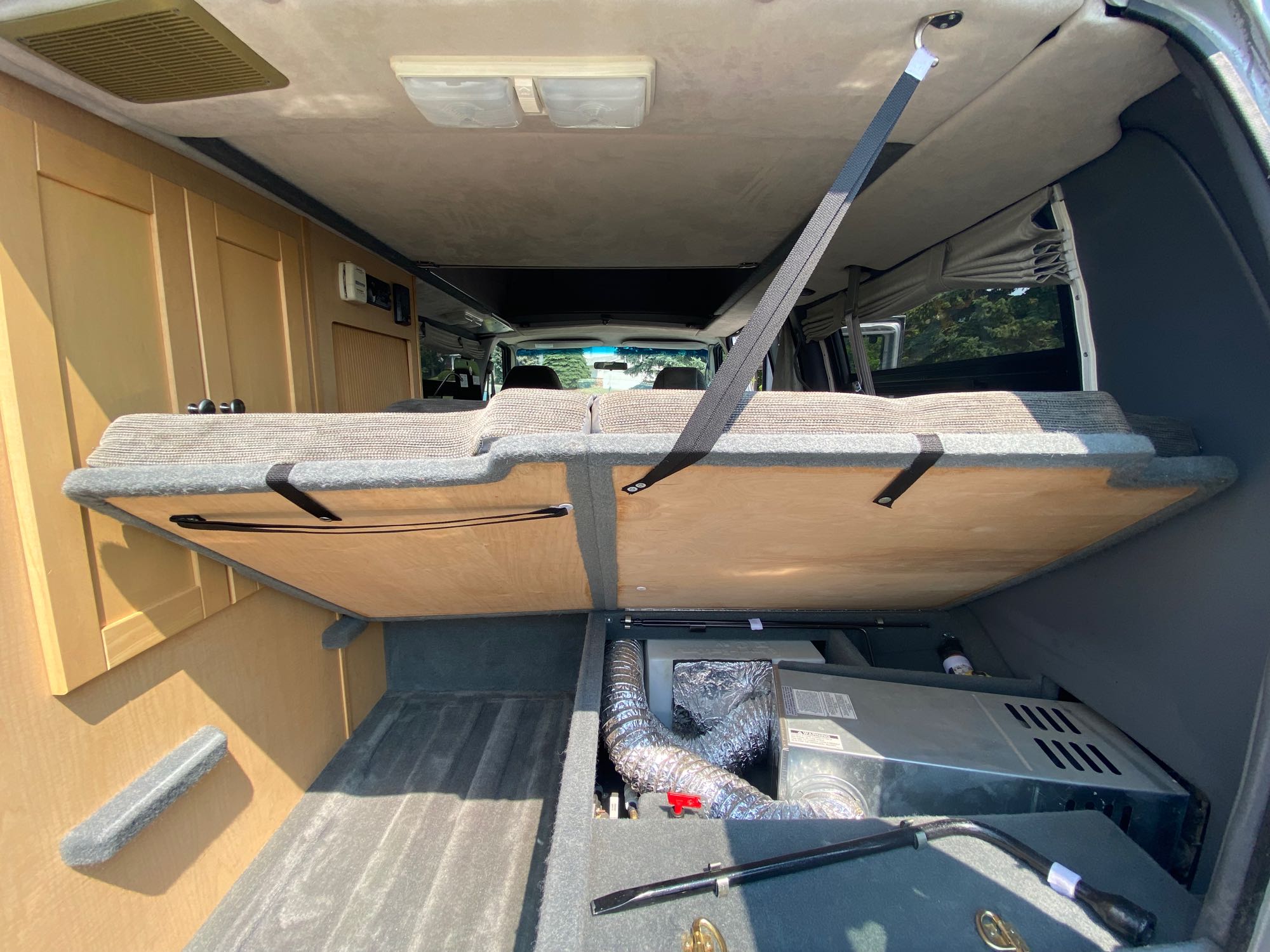 RV rental interior: A folded bed reveals under-bed storage with an HVAC unit and ducting, showcasing efficient camper space.. Pleasure-Way Pleasure-Way Class B 2007