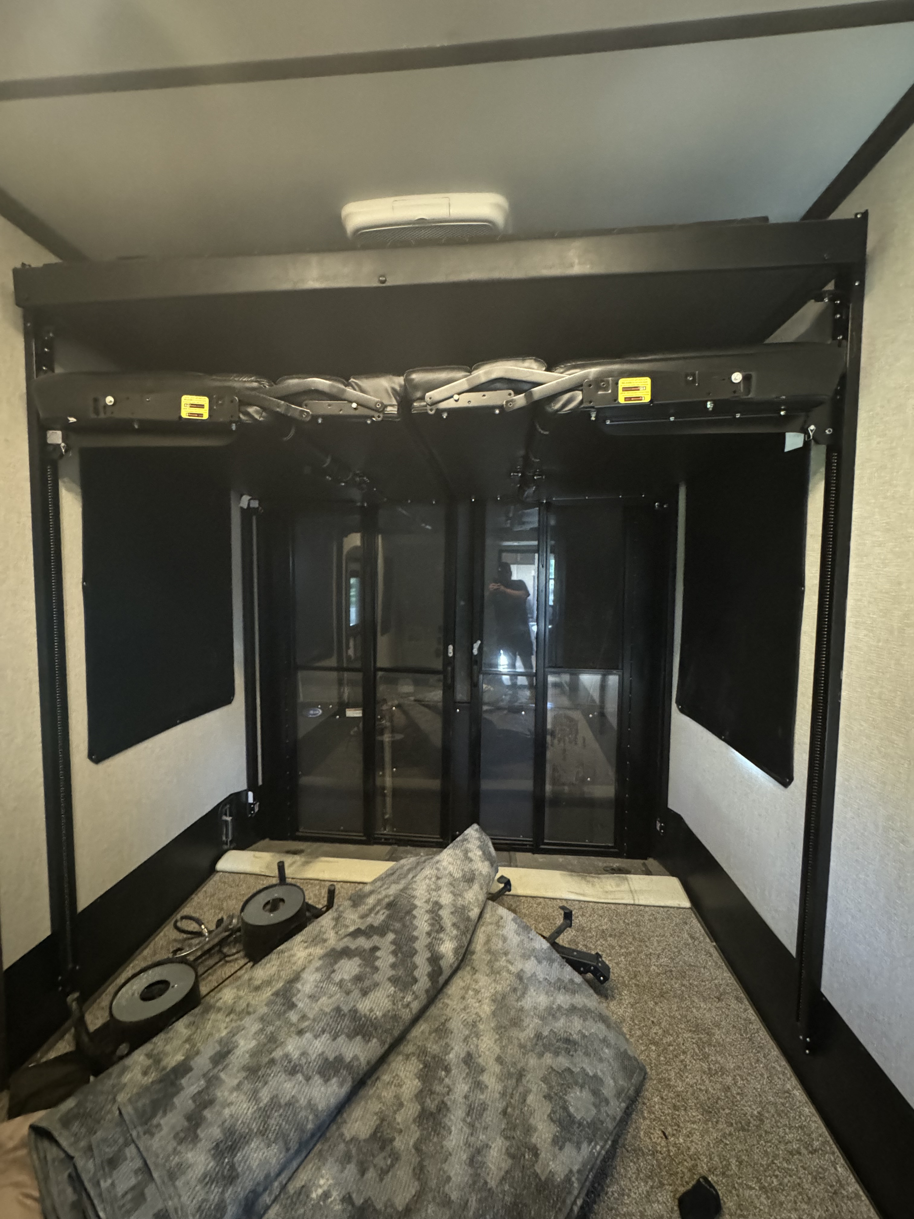 RV rental toy hauler's spacious rear garage area with folded bunk beds/sofas and a large ramp door.. Keystone Raptor 2020