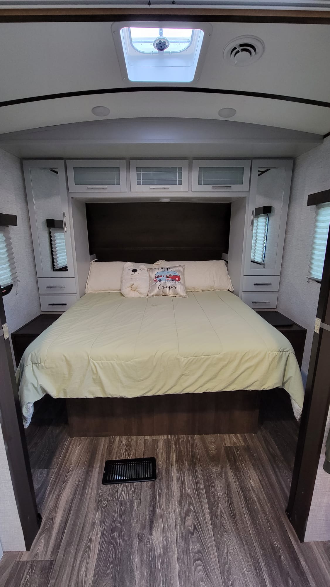Cozy RV rental bedroom with a spacious bed, overhead cabinets, and a skylight. Perfect for comfortable travel.. Keystone RV Bullet Ultra Lite 2021