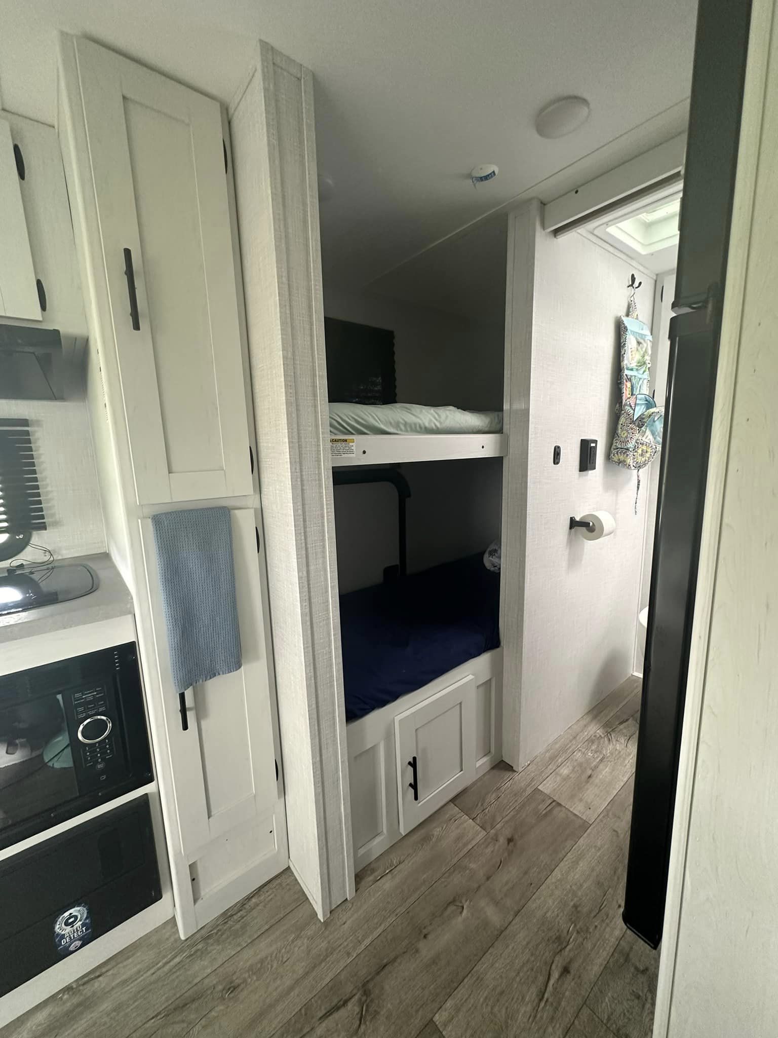 This RV rental features a bunkhouse setup, a compact kitchen with microwave, and an adjacent bathroom.. Coleman by Dutchman Rubicon 1708BH 2024