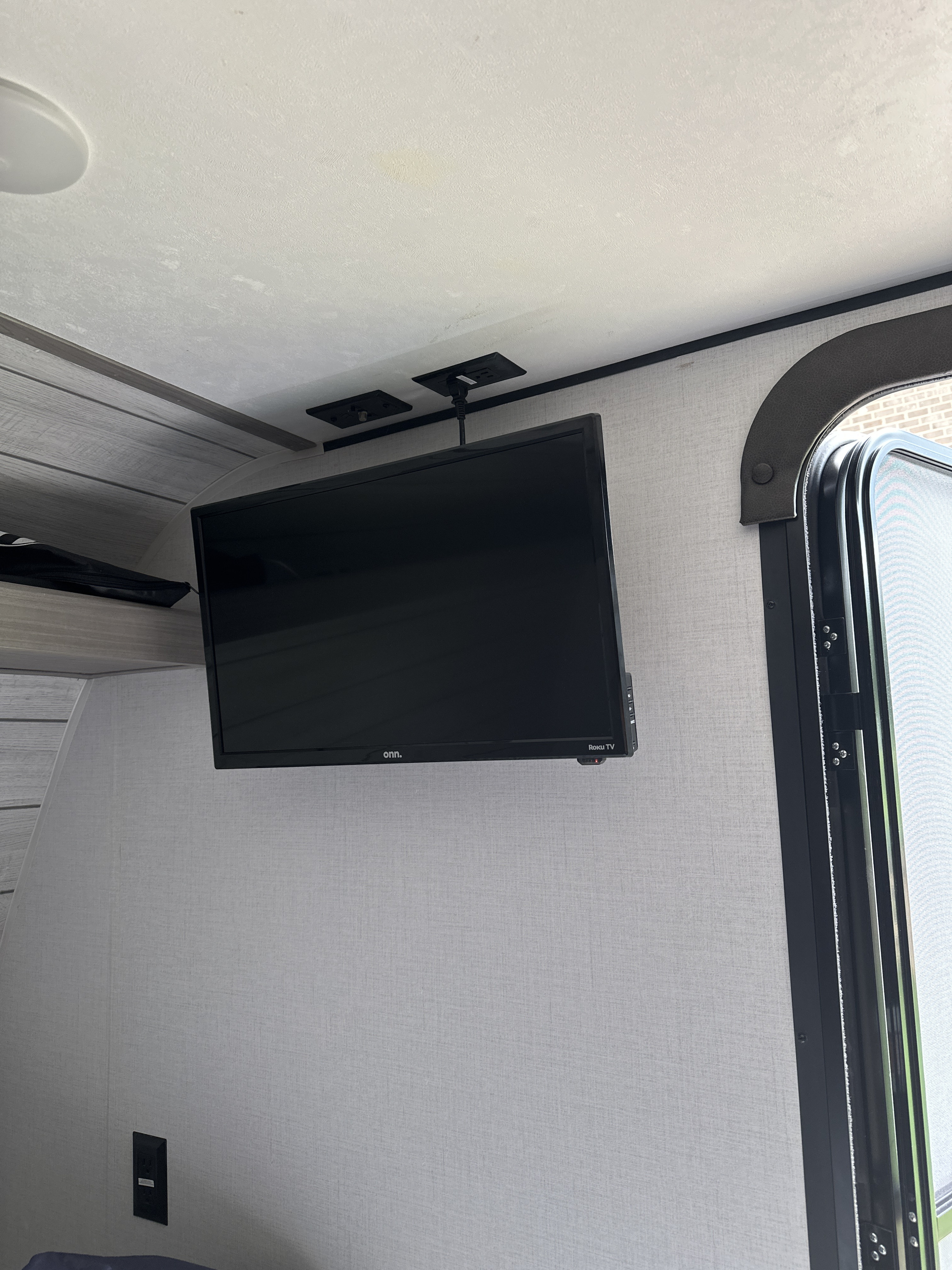 This RV rental interior features a ceiling-mounted TV, power outlets, and a compact living area, perfect for travel.. Coleman Lantern 2024