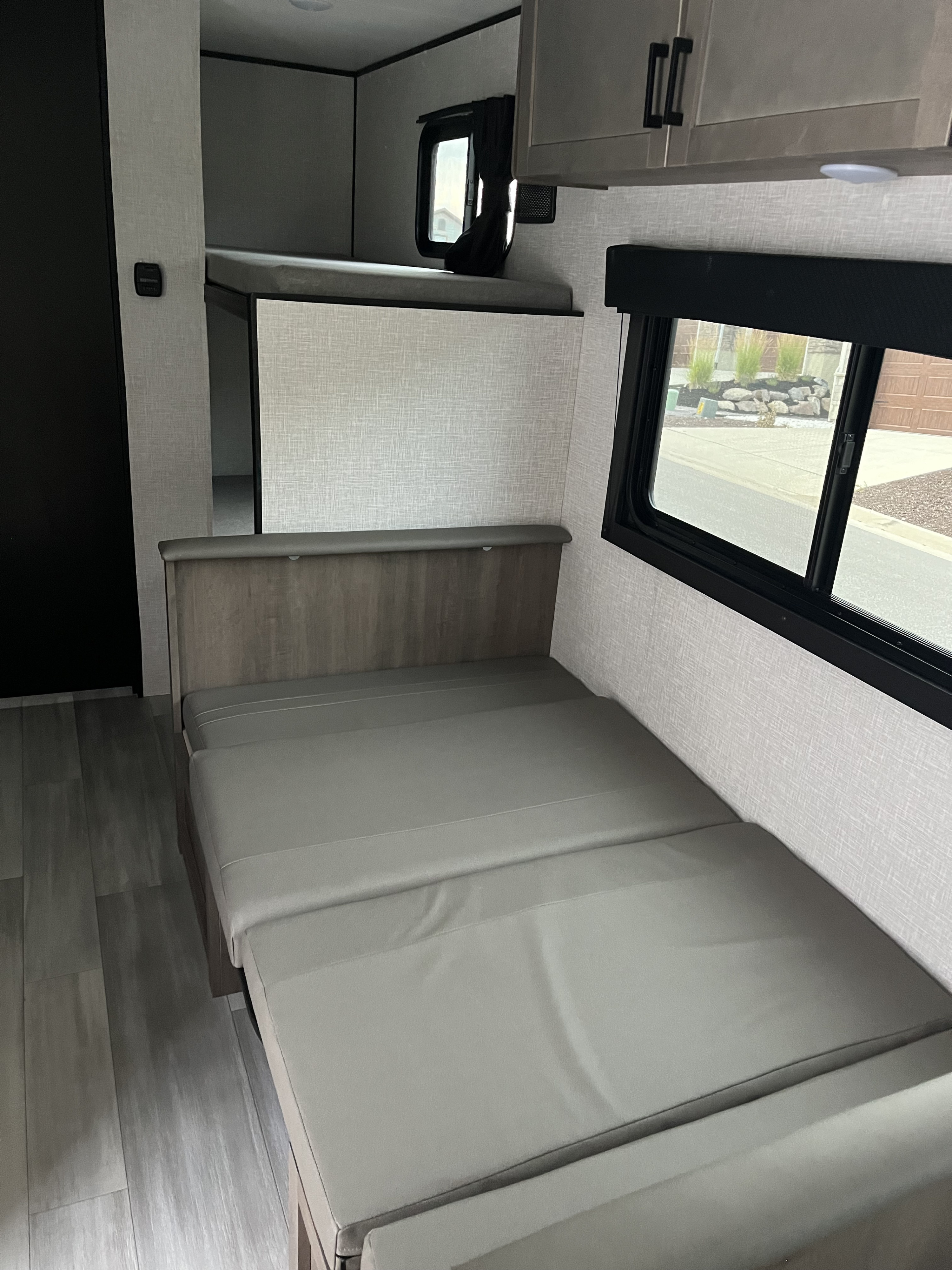 Spacious RV rental interior featuring a convertible dinette/bed, bunk beds, and overhead storage. Ideal for travel.. Highland Ridge Open Range 2025