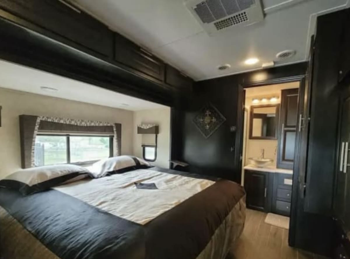 This comfy RV rental features a spacious bedroom with overhead storage, a window, and an attached bathroom.. Georgetown XL 2016