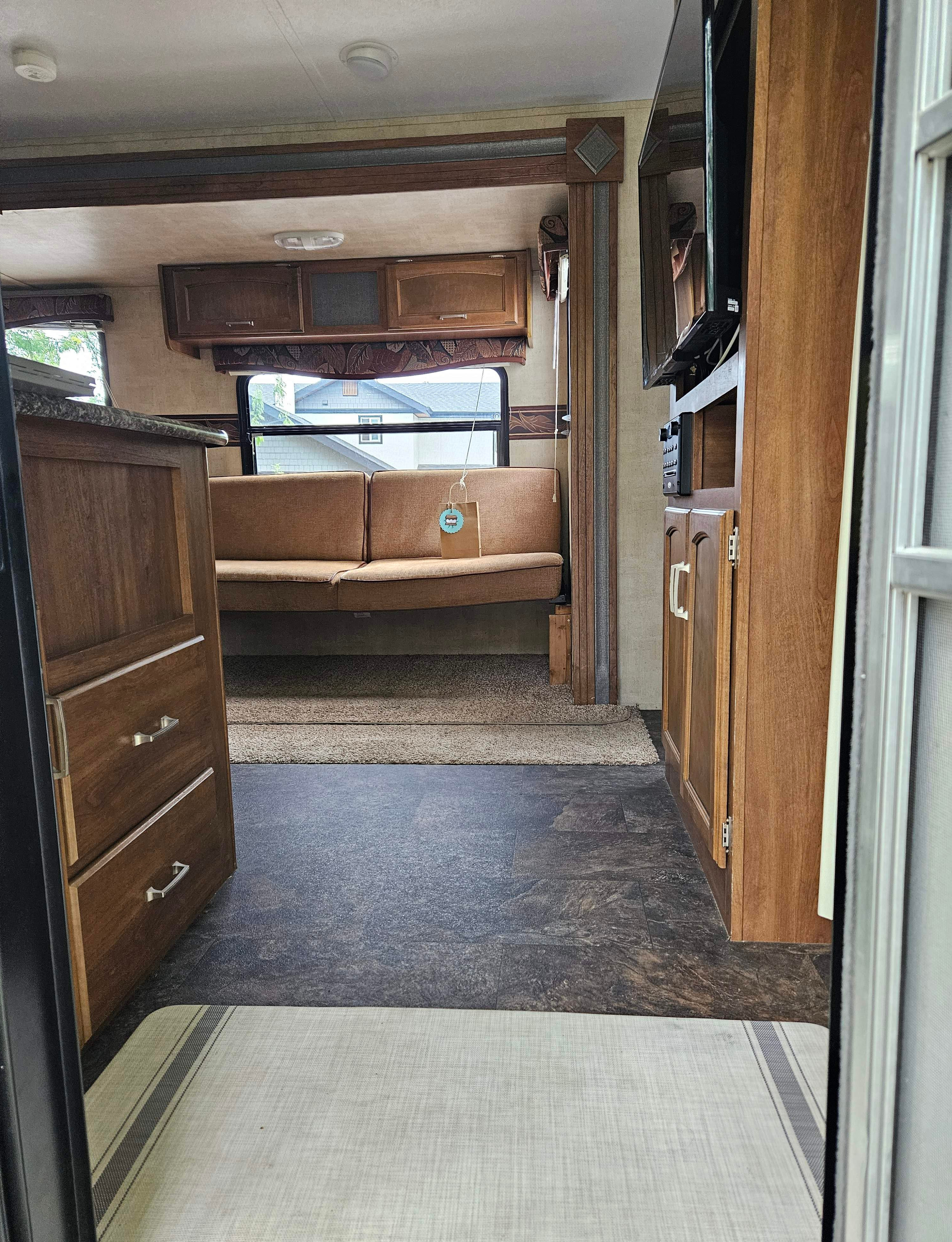 Inside this inviting RV rental: comfy sofa/dinette, wood cabinets, entertainment center, and sleek flooring.. Keystone RV Springdale 2014