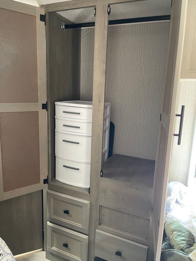 RV rental: Interior wardrobe featuring hanging rods, multiple drawers, and shelves for organized storage.. Forest River Coachmen Crosstrail 2023