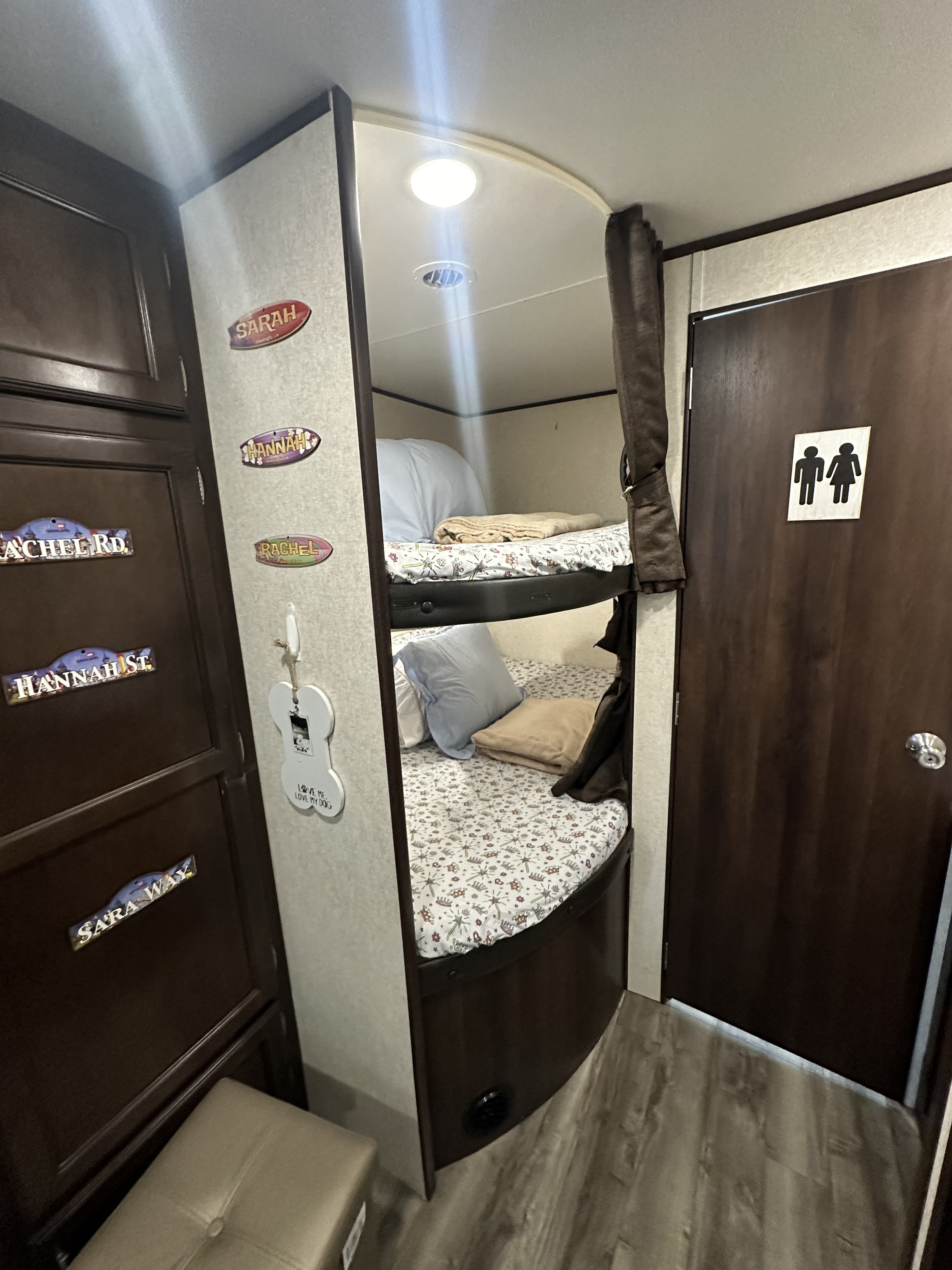 An RV rental interior featuring comfortable bunk beds, built-in storage, and playful personalized decor like names and a dog bone sign.. Jayco Jay Flight SLX 2019